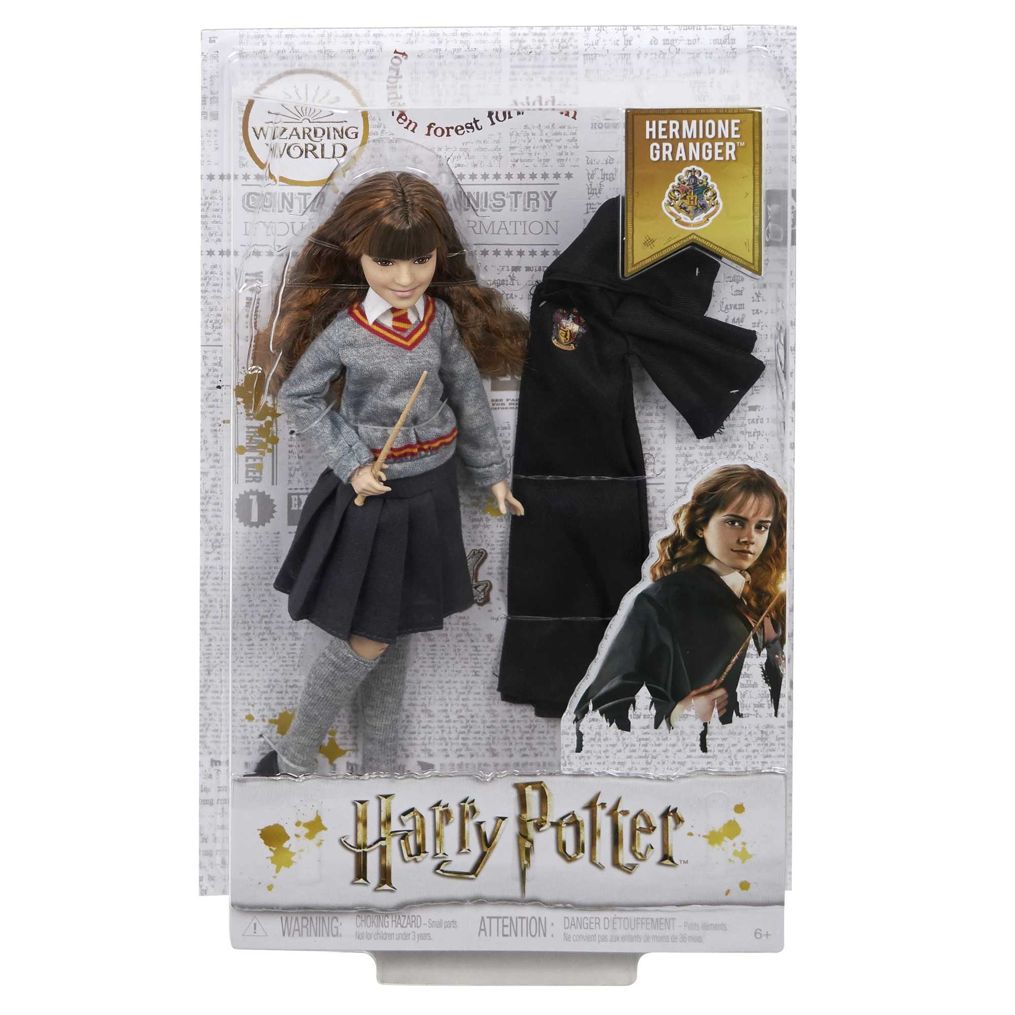 Hermine Granger Puppe in Uniform, mit Zauberstab und Umhang, verpackt in einer Harry Potter Box.