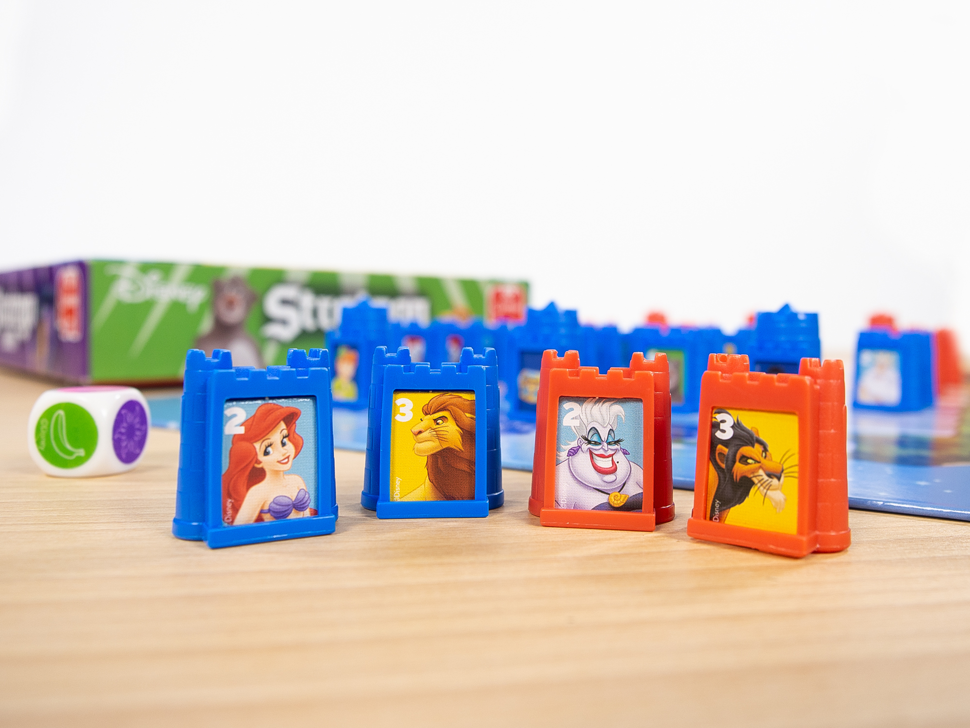 Piezas del juego Disney Stratego Junior con personajes de Disney en un tablero.