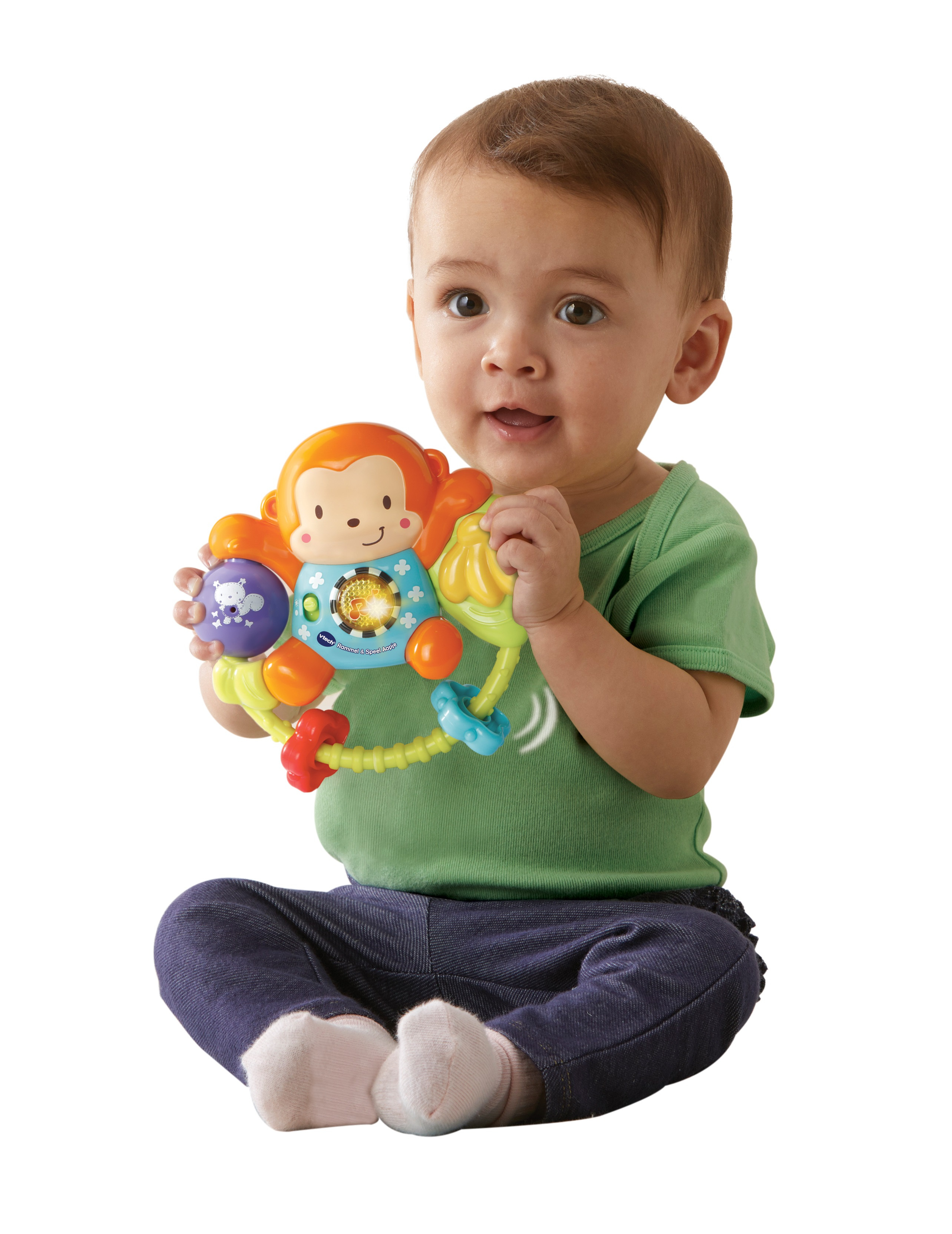 Baby hält ein Spielzeug-Äffchen mit Lichtern. Das Baby sitzt und trägt ein grünes Hemd und blaue Hosen.