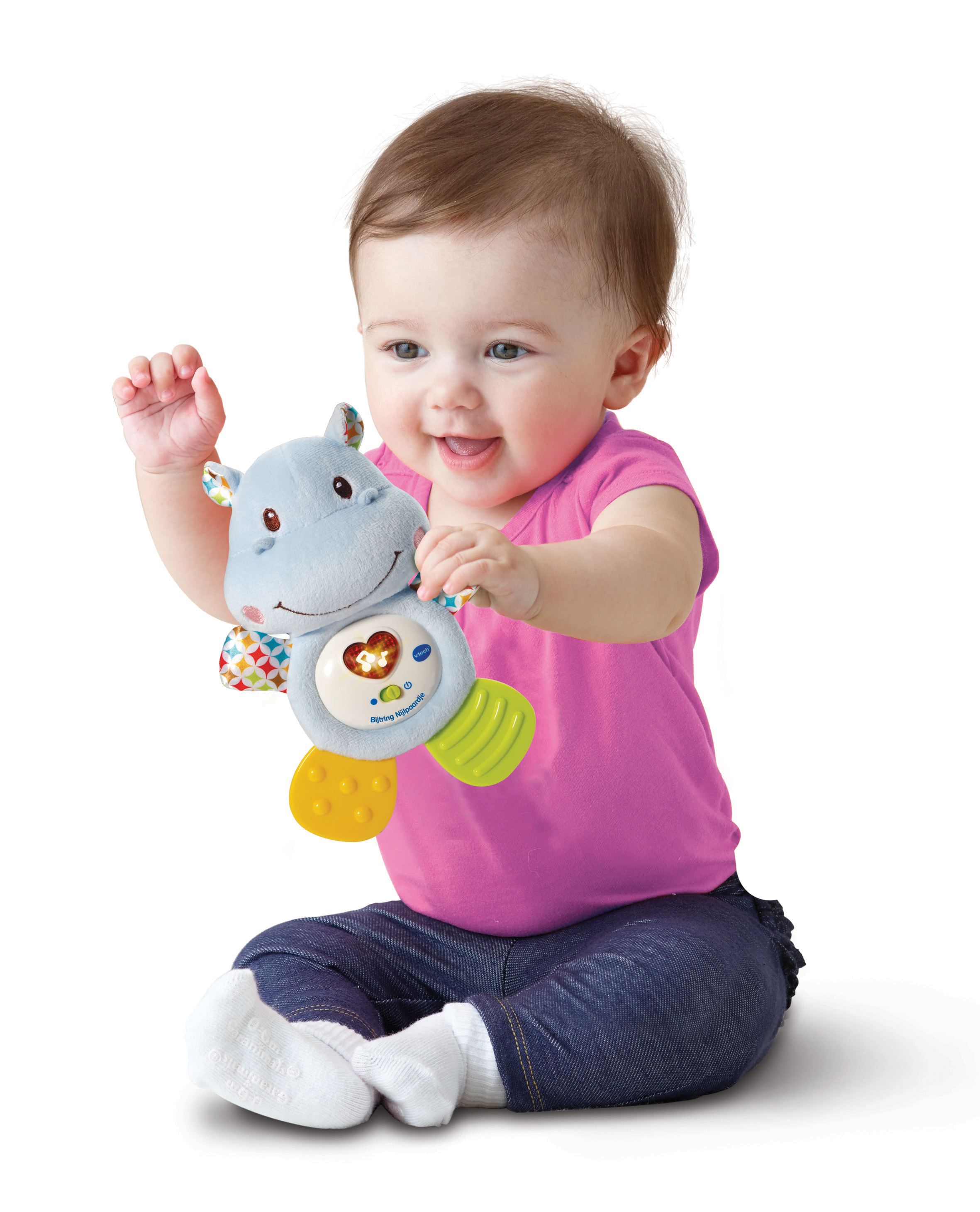 Ein Baby hält ein blaues Hippo-Spielzeug mit Licht und Lautsprechern. Das Baby lächelt und sitzt auf dem Boden.