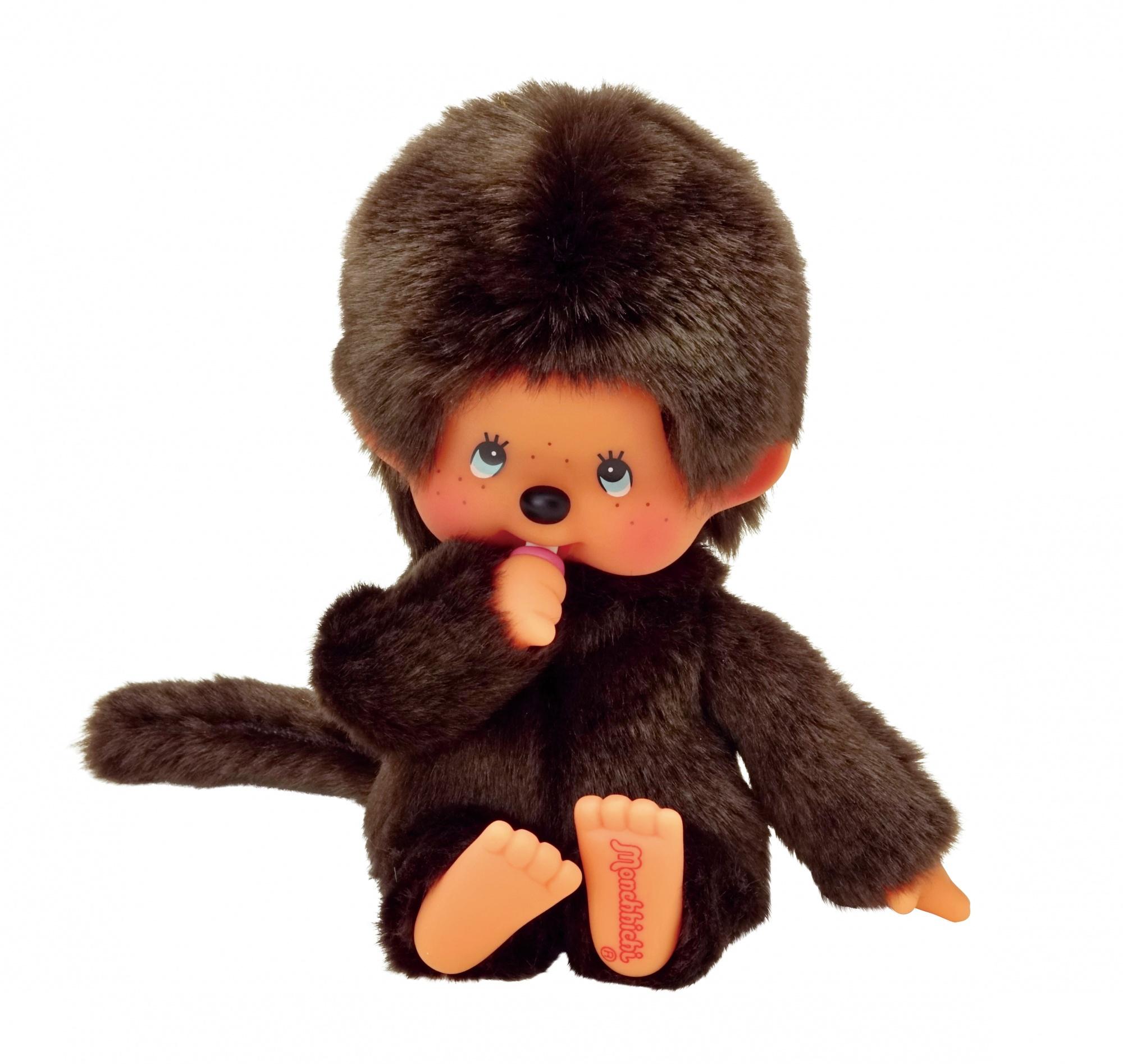 Brązowa lalka Monchhichi ze smoczkiem w ustach. Białe tło.