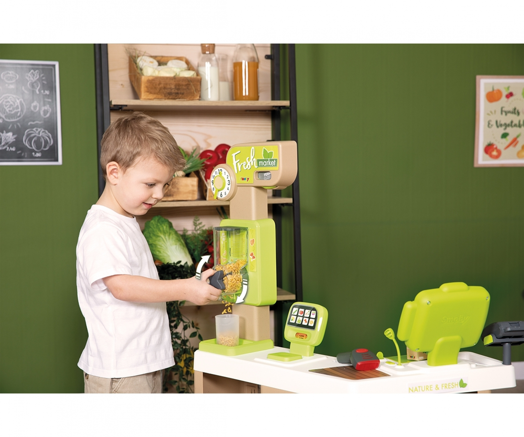 Dziecko bawi się zabawką. Zielony, beżowy i biały, z widocznymi różnymi zabawkami spożywczymi.