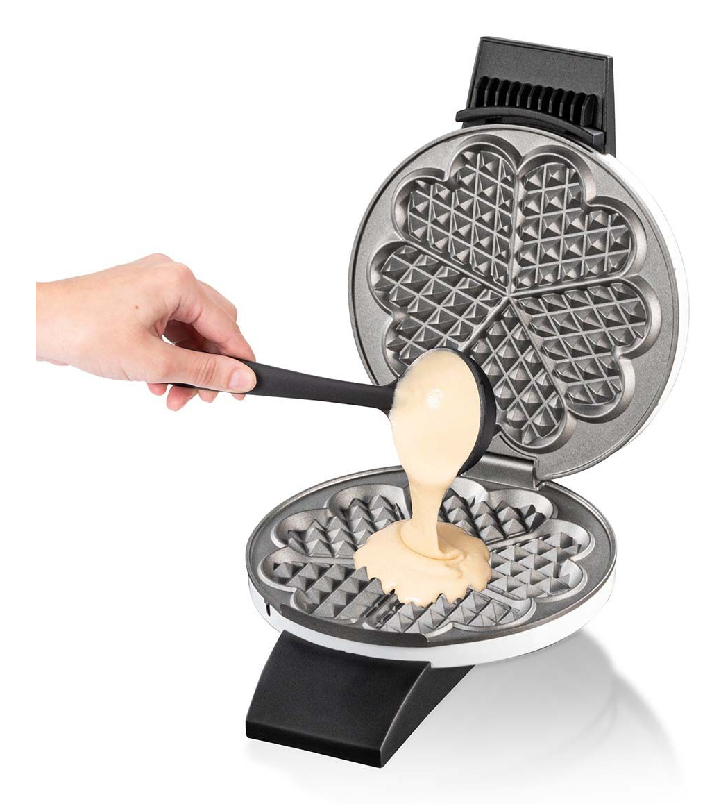 Gofrownica z ciastem wlewanym do niej czarną chochlą.