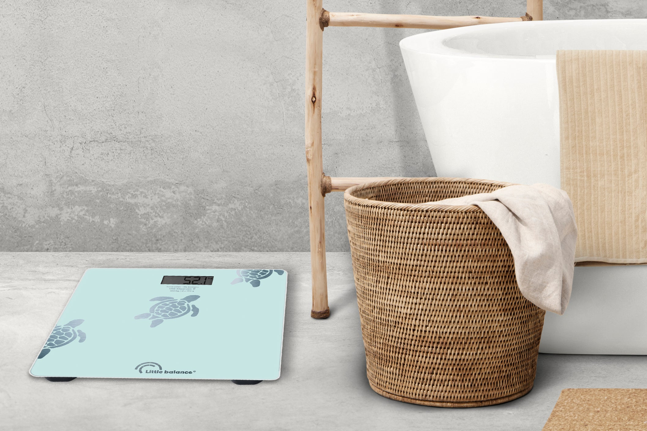 Scena łazienkowa: waga, wzór żółwia, wiklinowy kosz i ręcznik.