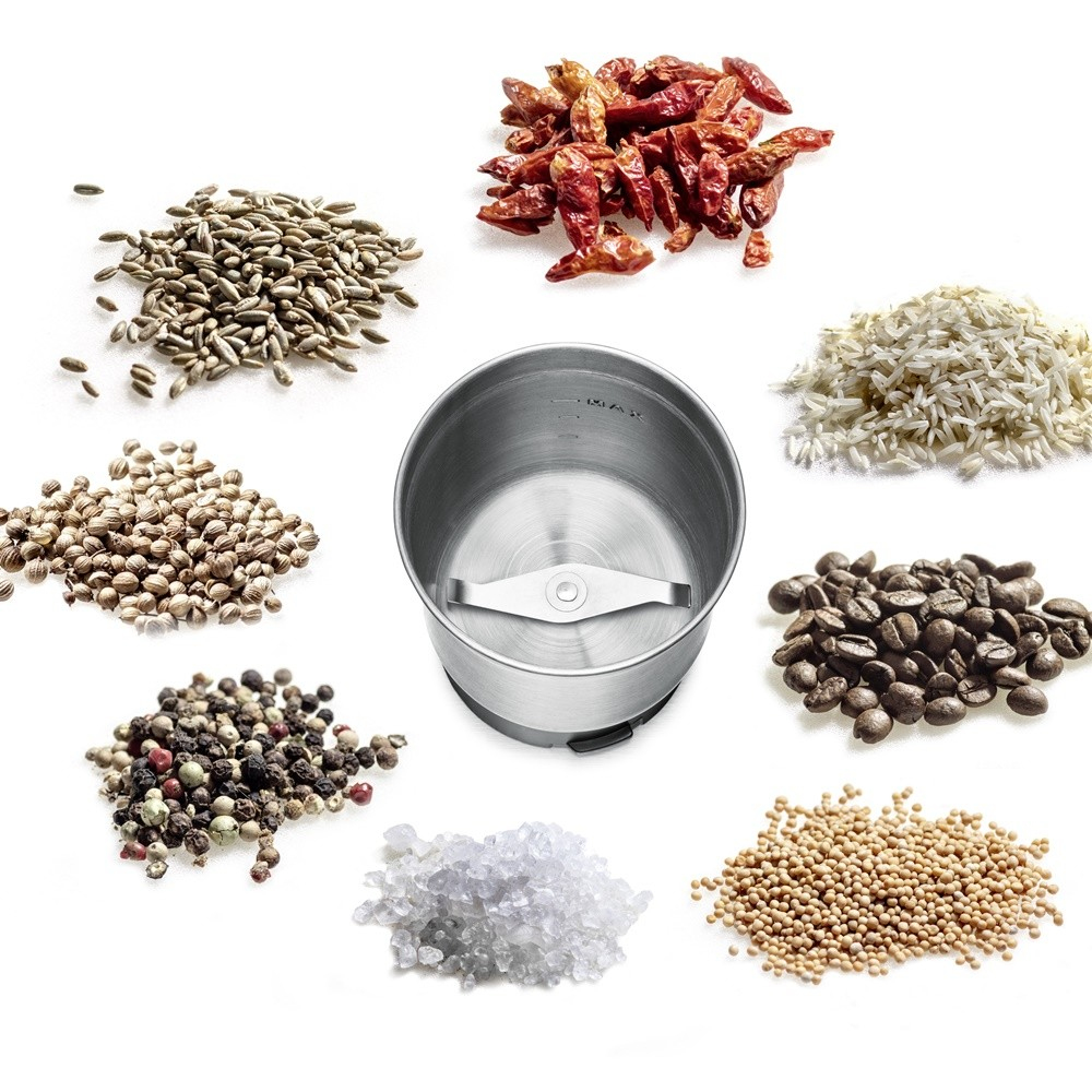 Młynek do przypraw z różnymi przyprawami wokół. Na białym tle.