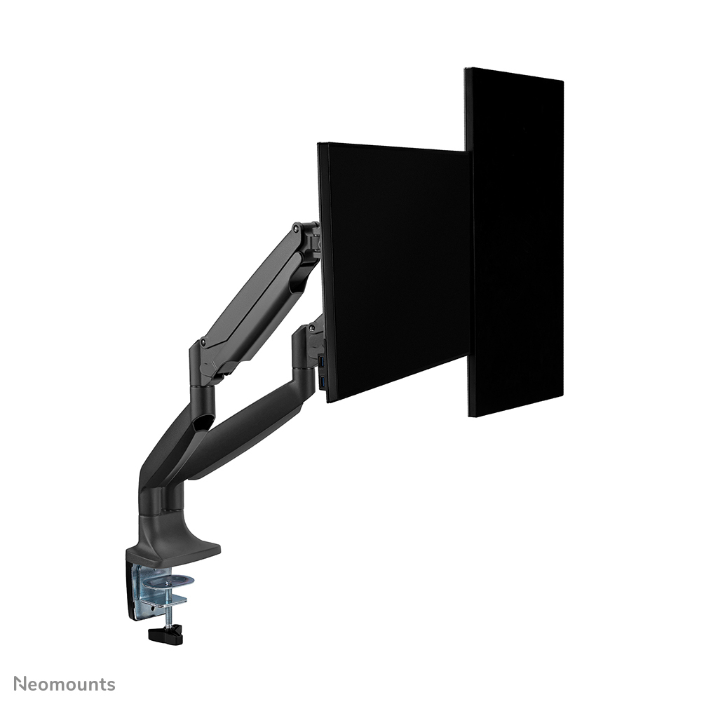 Un brazo de doble monitor negro con dos monitores negros. El brazo está sujeto a una superficie blanca.
