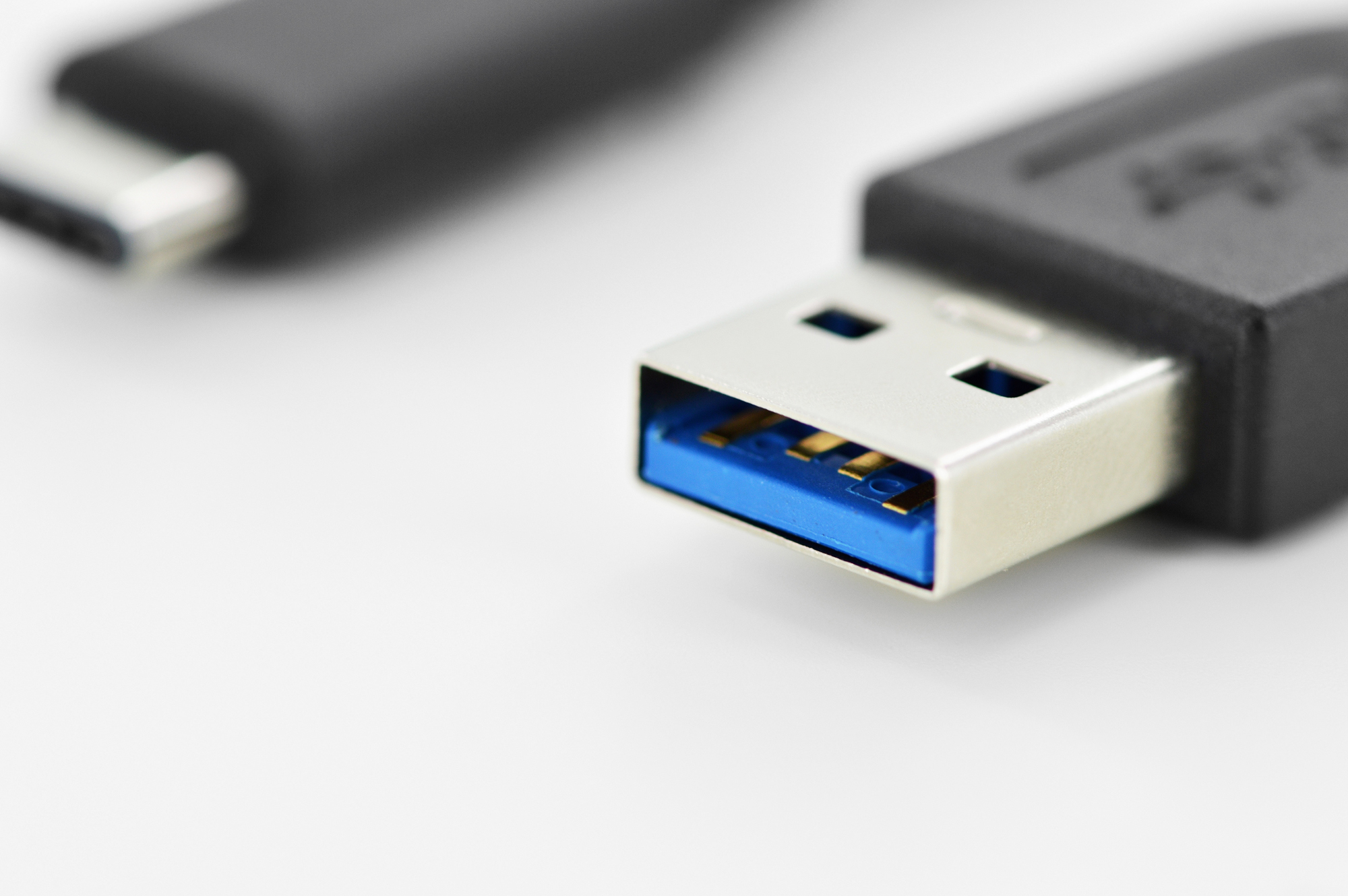 Kabel USB do USB-C z niebieskim wewnętrznym złączem na białej powierzchni.
