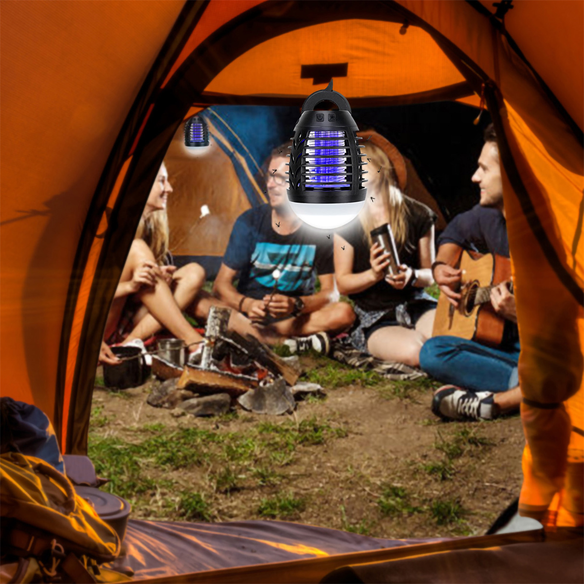 Menschen in einem Zelt bei Nacht, beleuchtet von einem Insektenvernichter, mit Lagerfeuer und Gitarre.