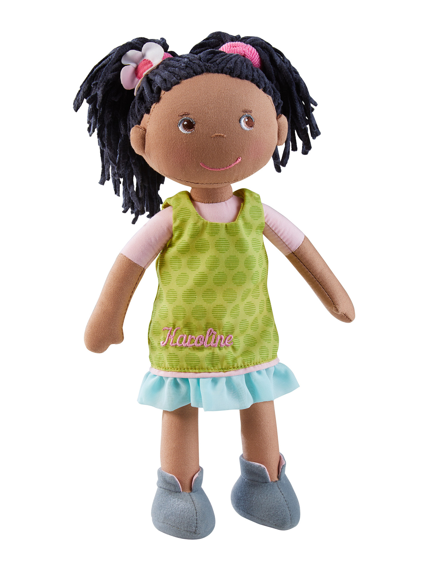 Eine Puppe mit schwarzen Haaren und einem grünen Kleid. Das Kleid hat den Namen 'Karoline' darauf.