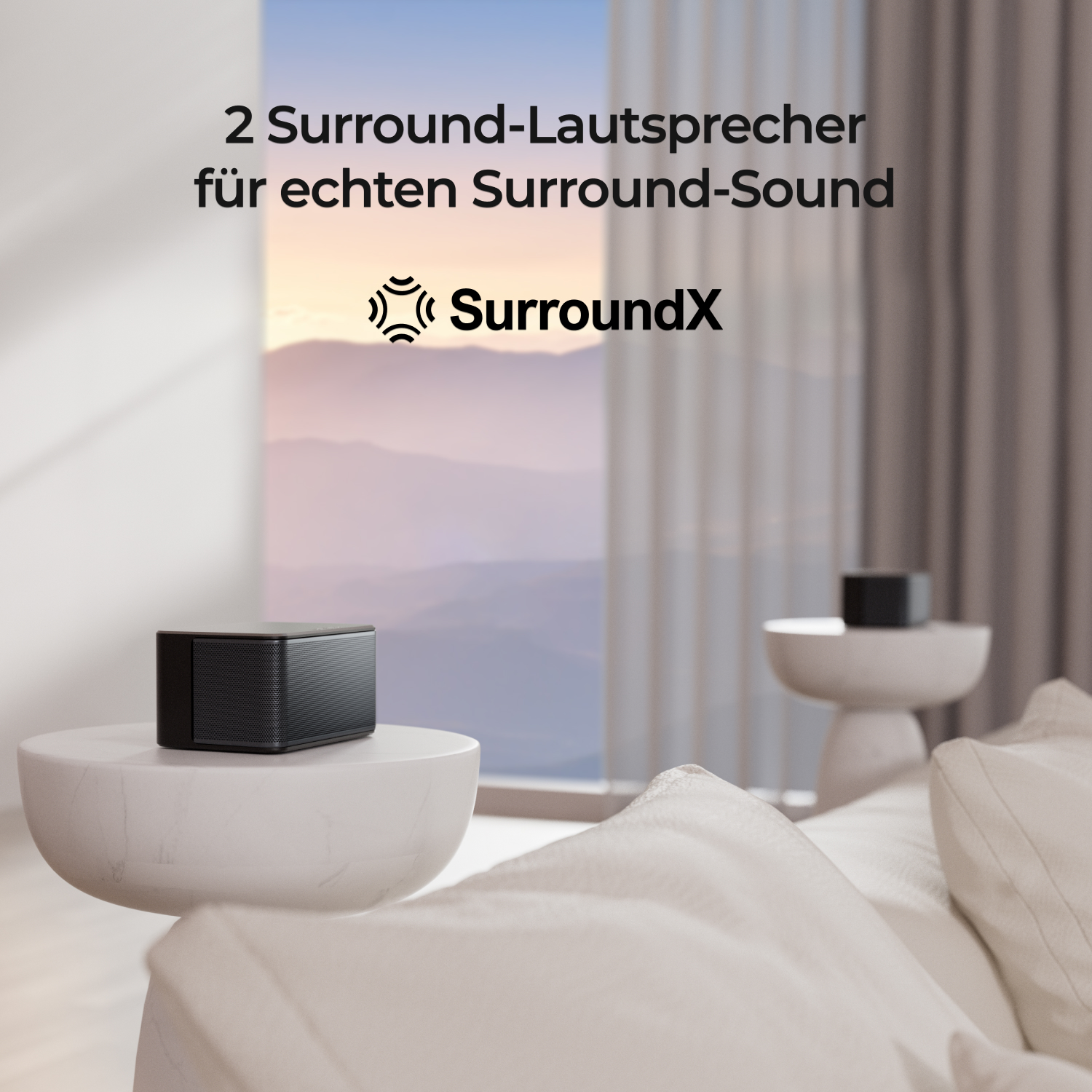 Zwei kleine schwarze Lautsprecher auf einem weißen Tisch in einem Wohnzimmer.