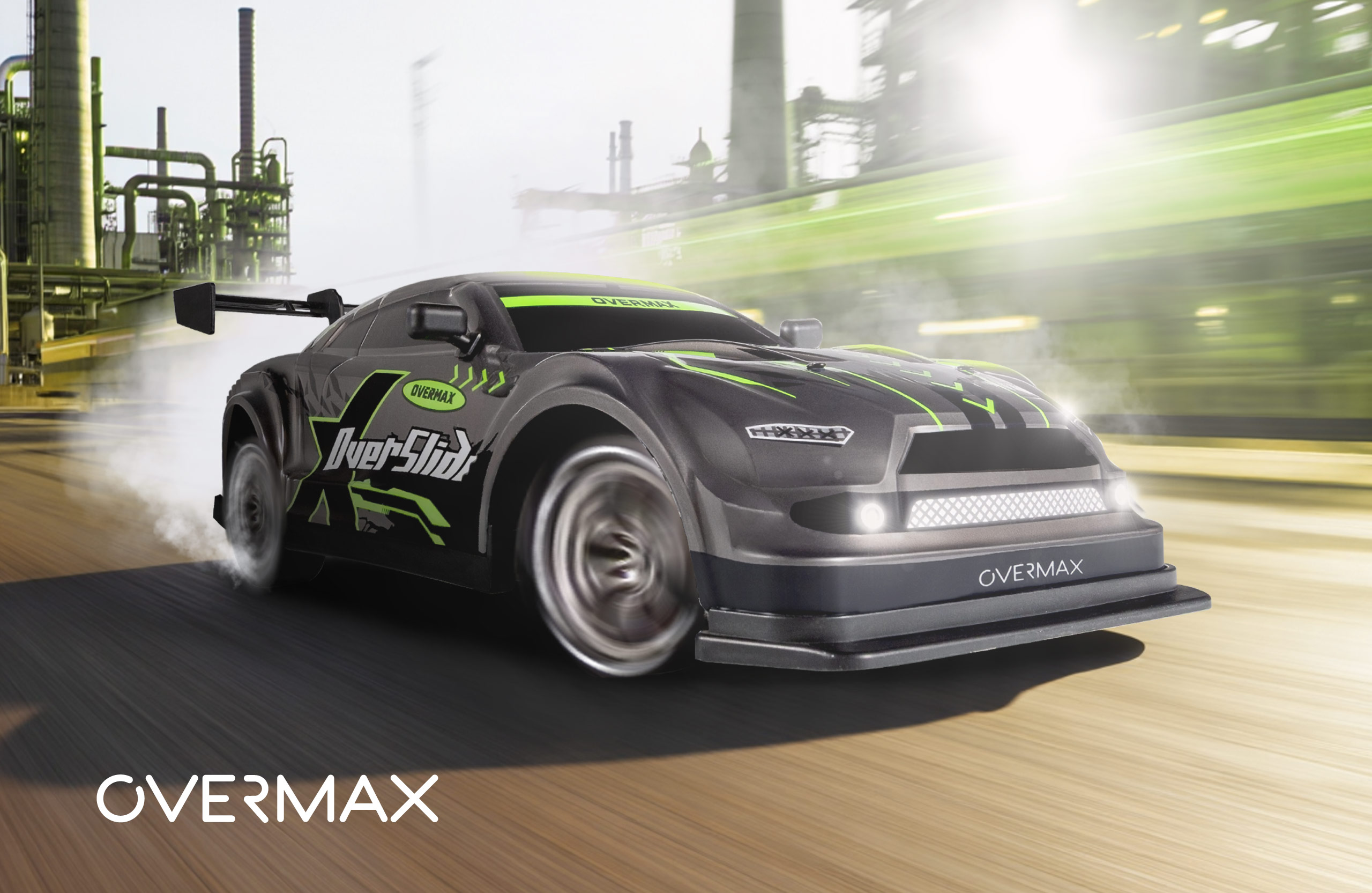 A black and green racing car with OVERMAX written on it, on a smoky background, with industrial structures.