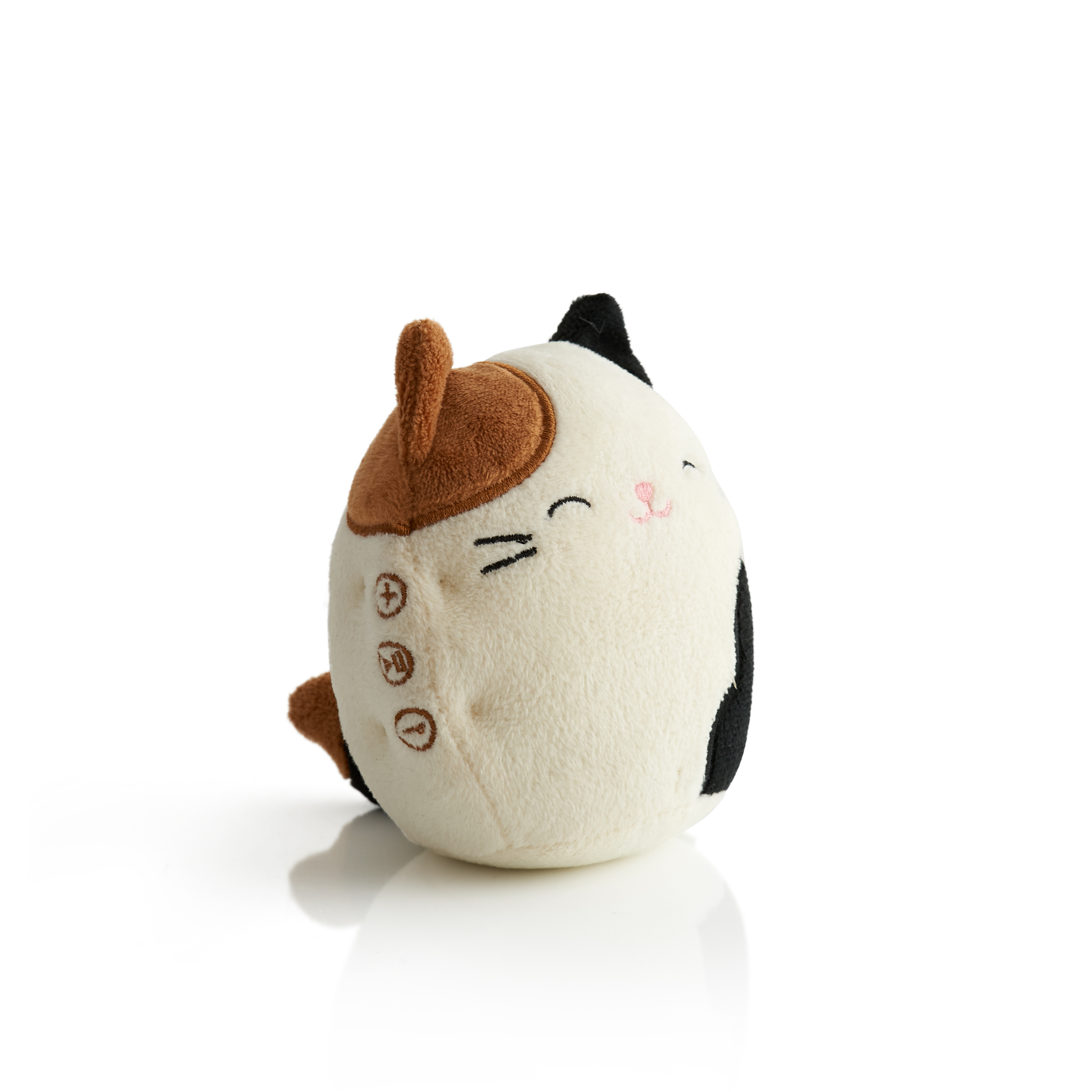 Een witte en crèmekleurige kattenknuffel met een zwart-bruin patroon. Lacht en heeft knopen.