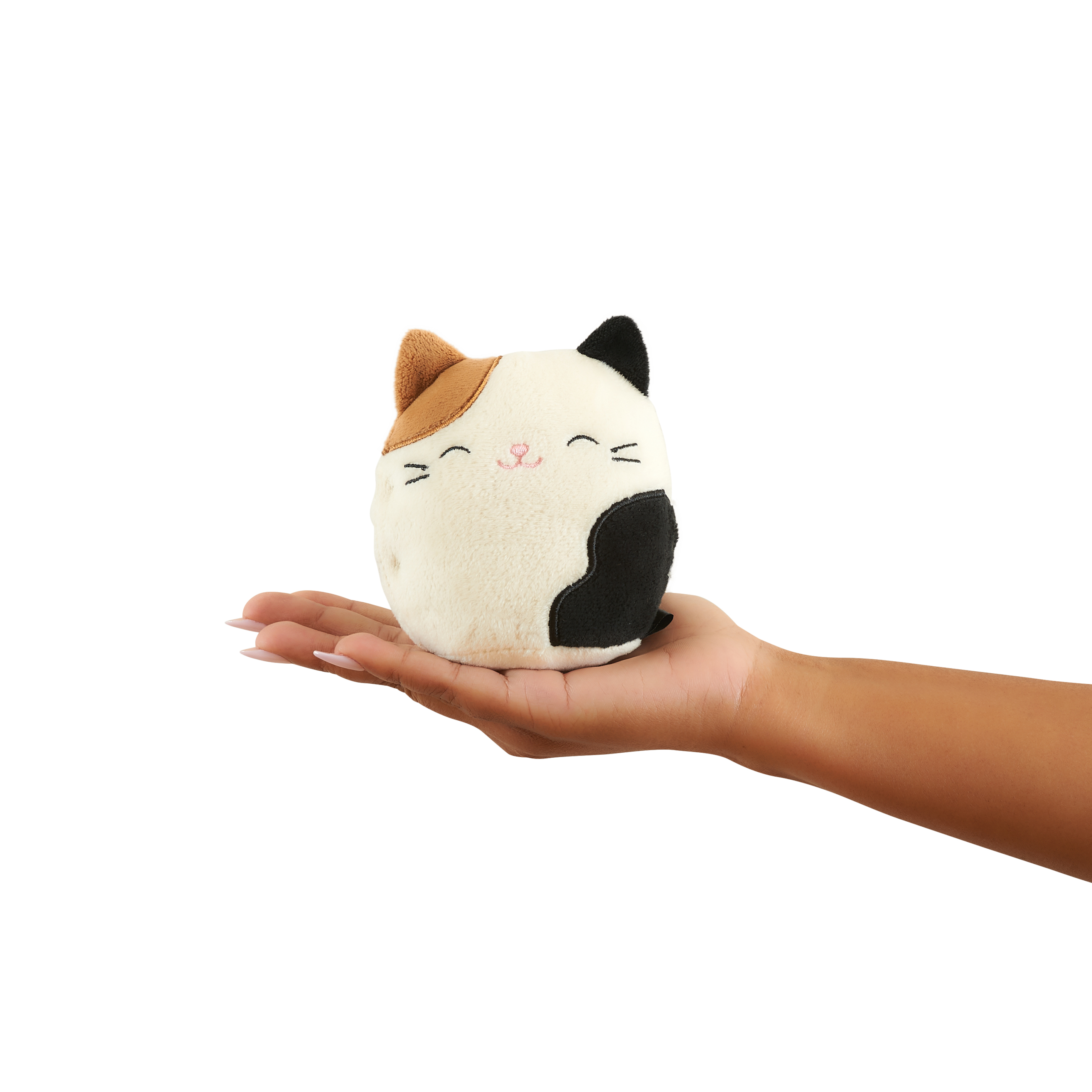 Een pluche kattenspeeltje in de hand van een persoon. De kat is wit, zwart en oranje.