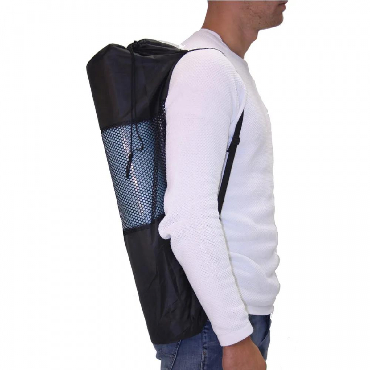 Une personne avec un tapis de yoga dans un sac noir sur l'épaule. La personne porte une chemise blanche.