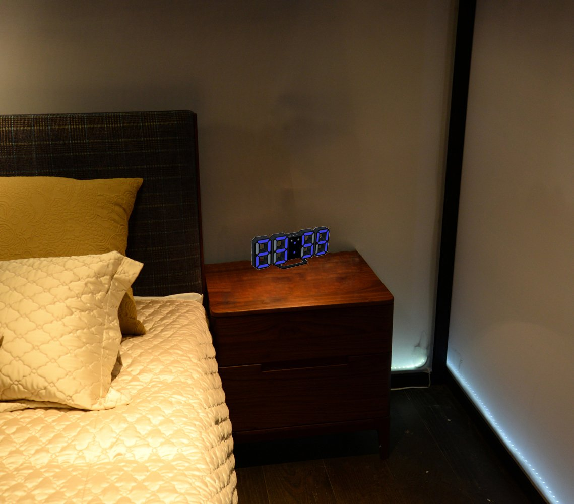 Schlafzimmer mit Bett und Nachttisch. Digitaluhr auf dem Nachttisch, die Zeit anzeigt. Dunkler Raum.