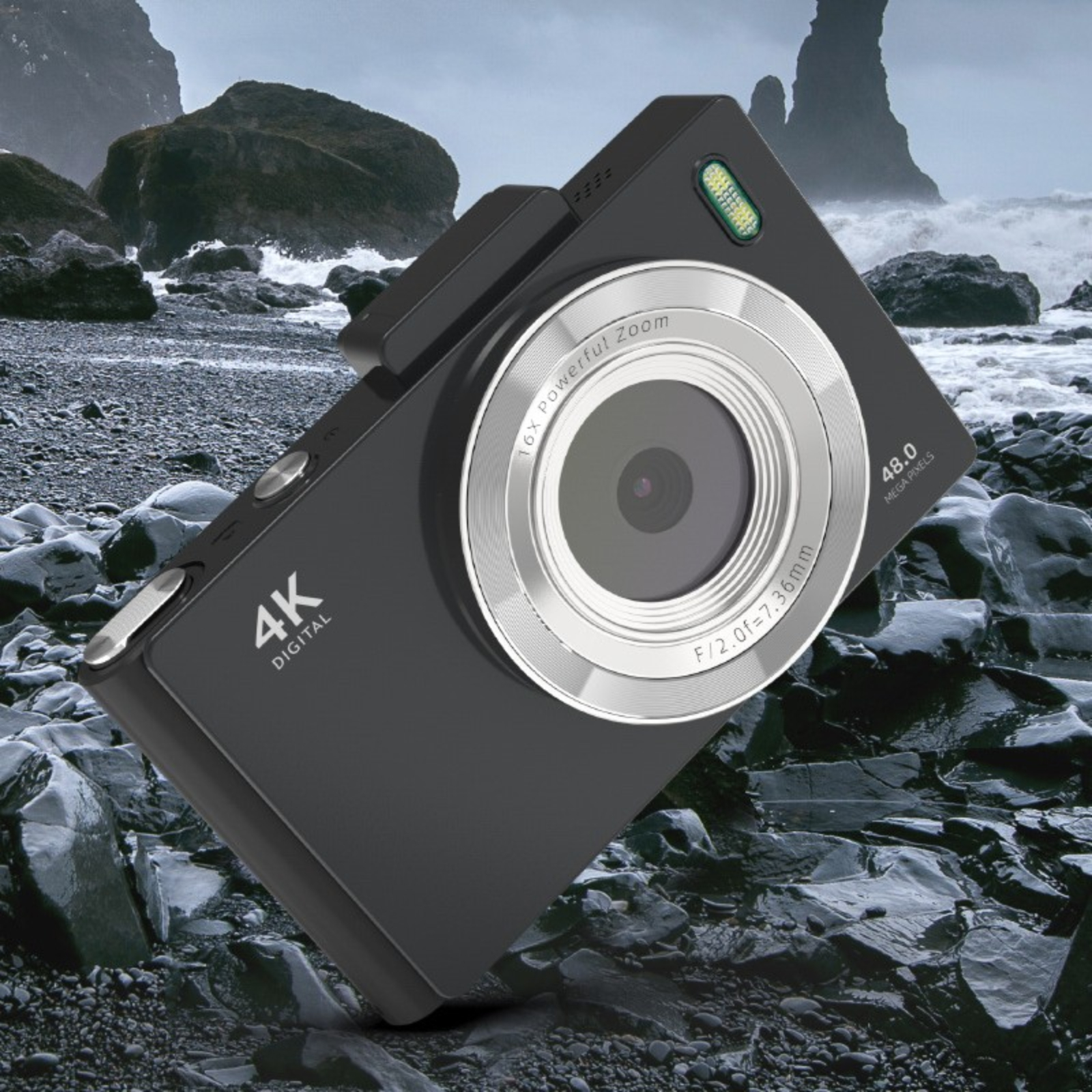 Schwarze Digitalkamera mit silbernem Objektiv auf Felsen. Strand- und Ozeanhintergrund.
