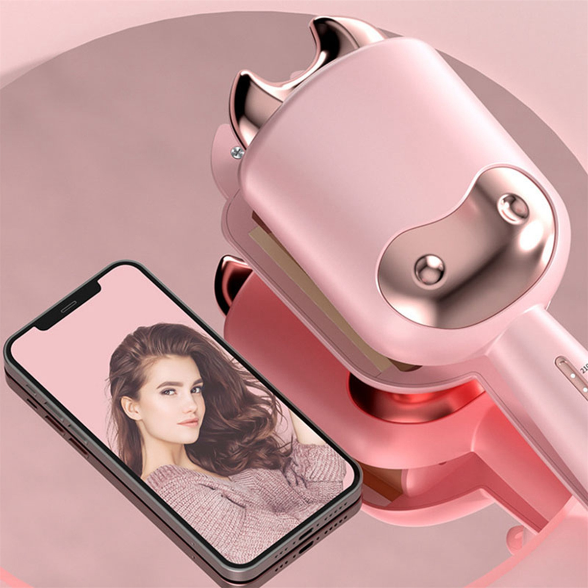 Ein rosa Lockenwickler und ein Telefon mit dem Bild einer Frau. Der Lockenwickler spiegelt sich auf einer rosa Oberfläche.