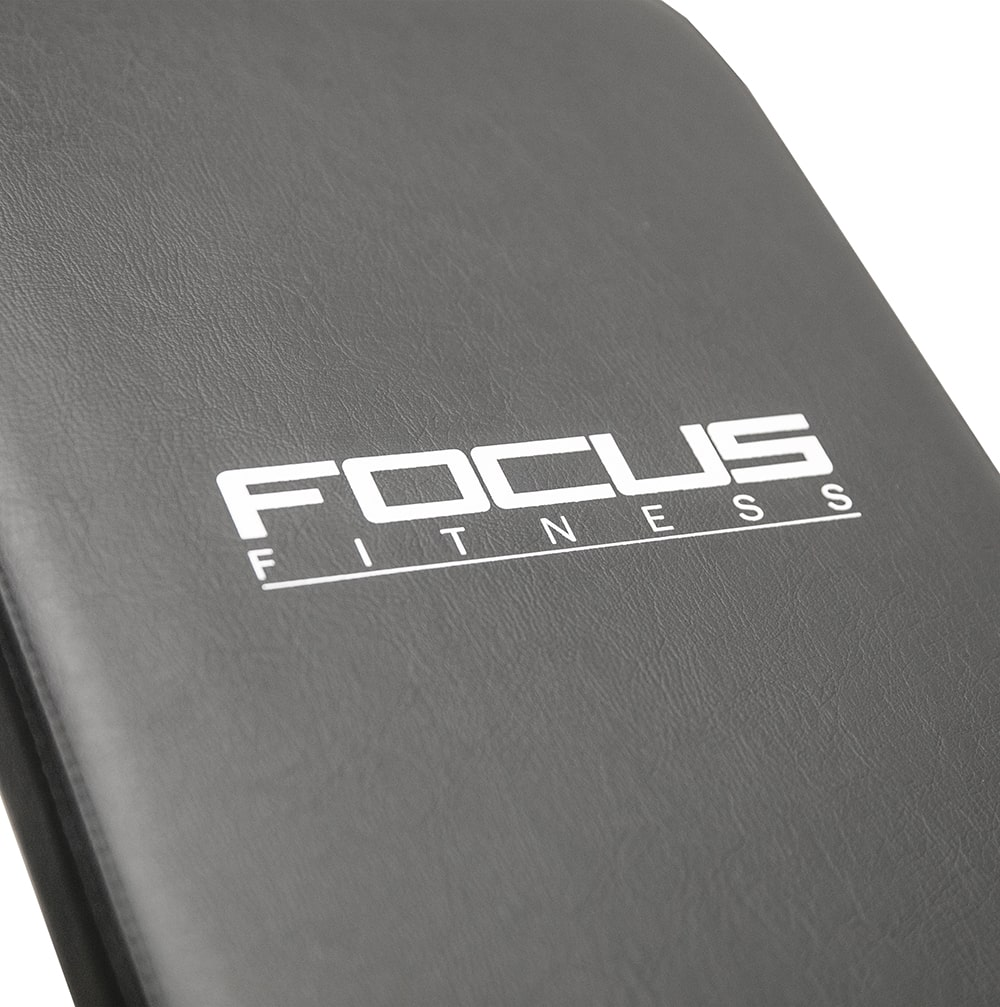 A close-up of a black fitness bench with FOCUS FITNESS written in white.