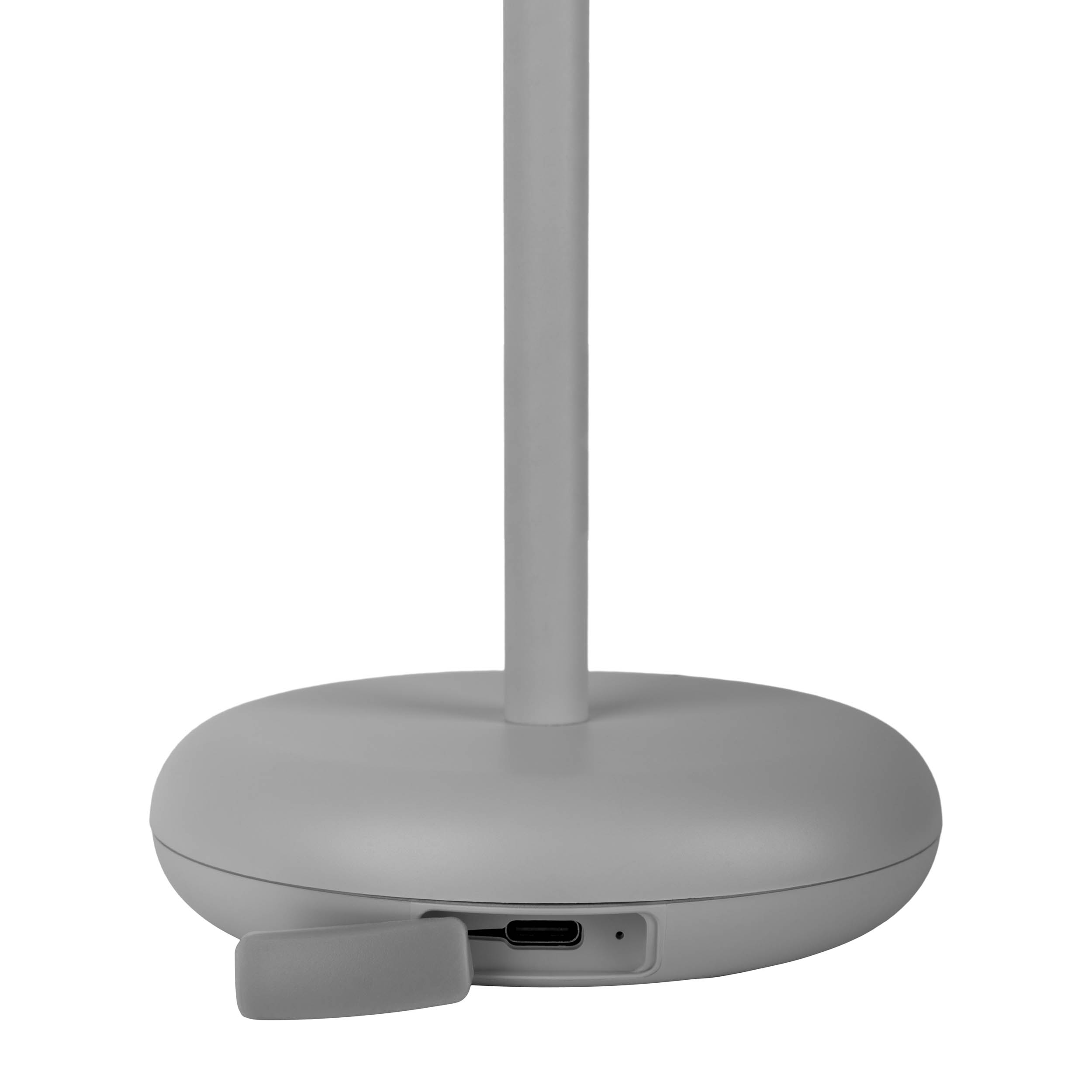 Ein grauer Lampensockel mit USB-Anschluss und Ein-/Aus-Taste. Ein Ladekabel ist eingesetzt.