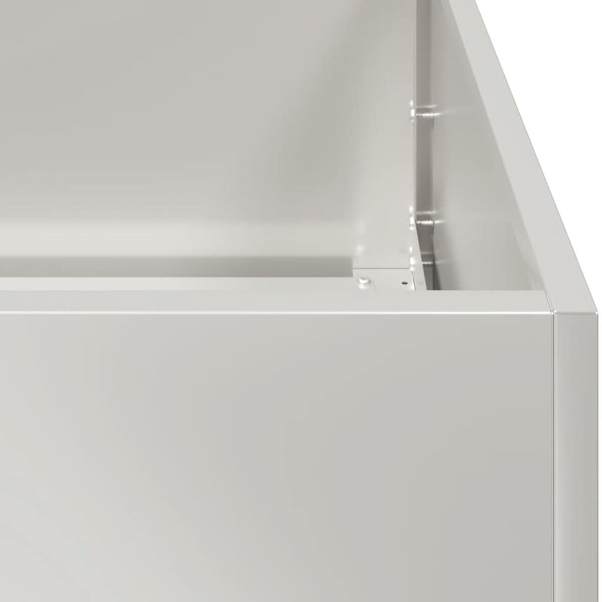 Primo piano di un angolo di una scatola di metallo bianco. L'angolo è retto, con viti visibili.