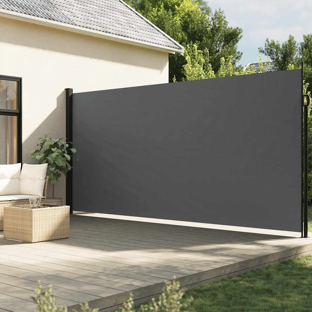 Ein einziehbarer Outdoor-Bildschirm in Grau, montiert auf einem Deck und einem Haus. Bäume im Hintergrund.