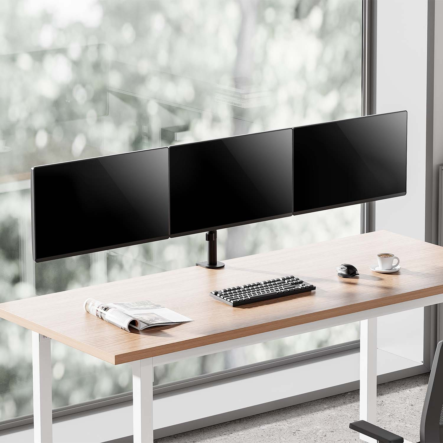 Escritorio con tres monitores negros, teclado, ratón y taza de café. Ventana al fondo.