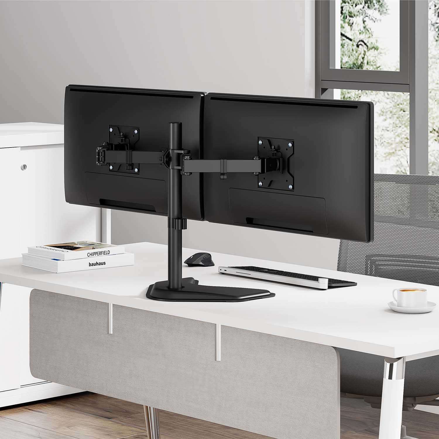 Soporte para monitor doble en escritorio blanco. Dos monitores sujetos. Teclado, ratón y libros en el escritorio.