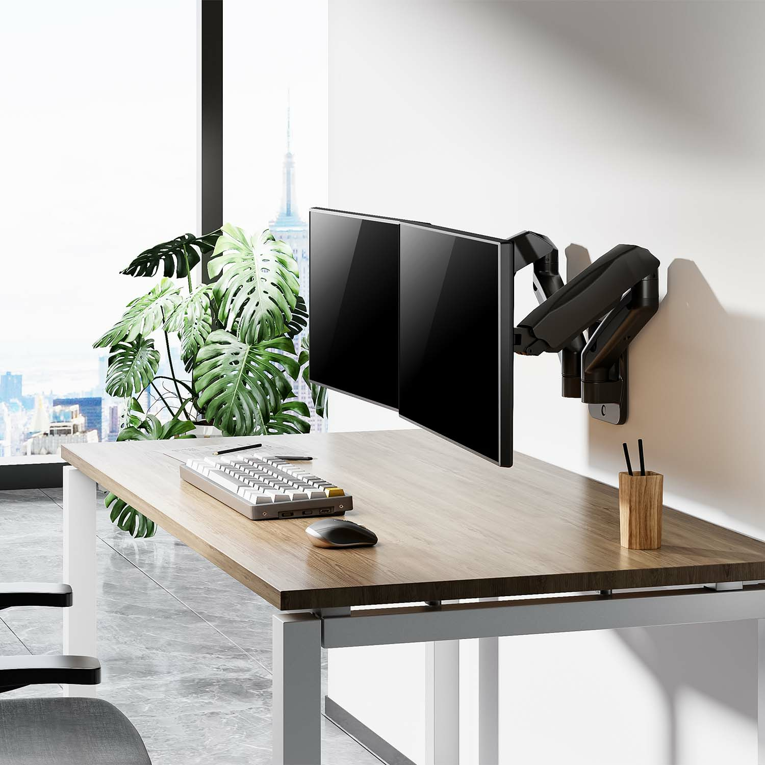 Dos monitores de ordenador negros montados en un escritorio con teclado, ratón y un portalápices de madera.
