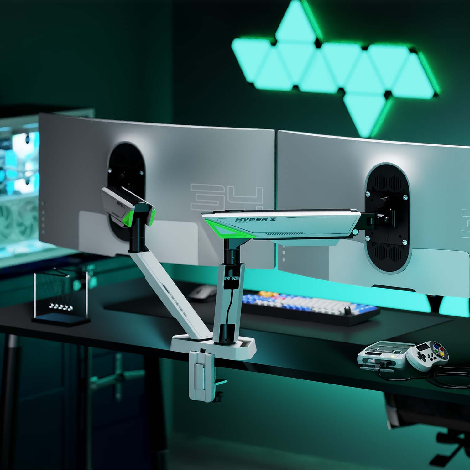 Monitores dobles en un escritorio negro con un brazo de monitor blanco y verde, un teclado y una consola de juegos.