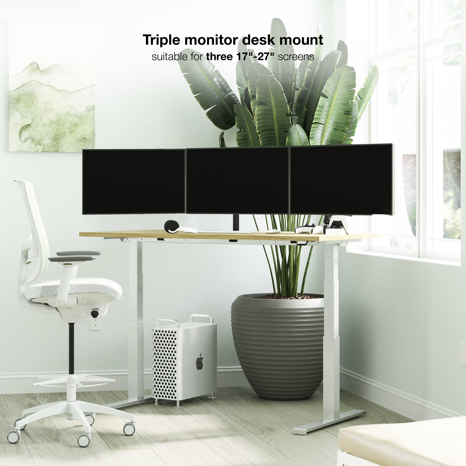 Konfiguracja z trzema monitorami na białym biurku z białym krzesłem. Duża roślina i biała wieża komputera.