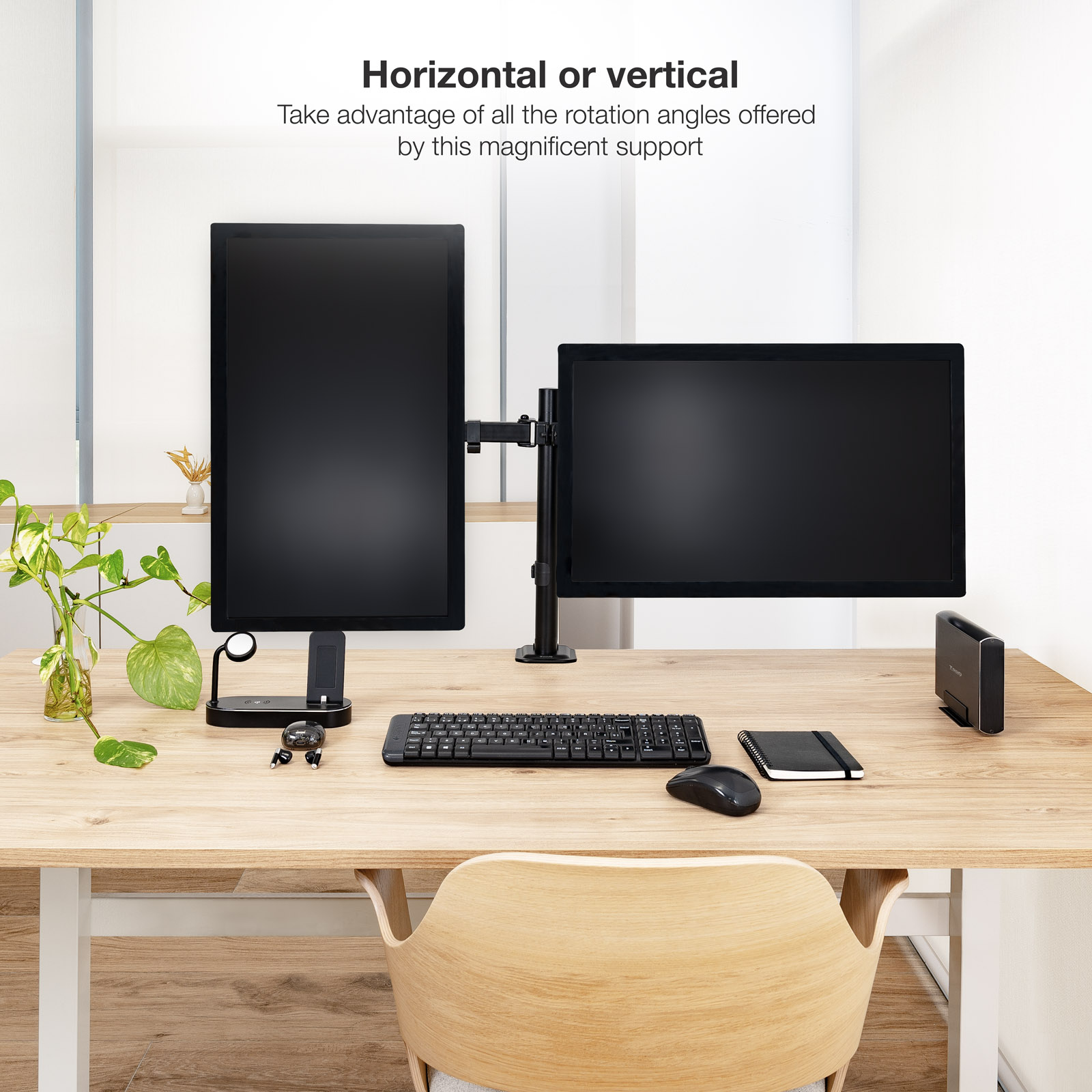 Una configuración de escritorio con dos monitores, un teclado, un ratón y un cuaderno sobre un escritorio de madera.