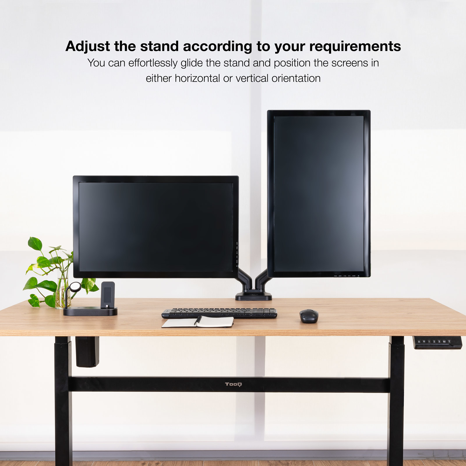 Dwa monitory na biurku, tekst 'Dostosuj stojak'. Czarna klawiatura i mysz.