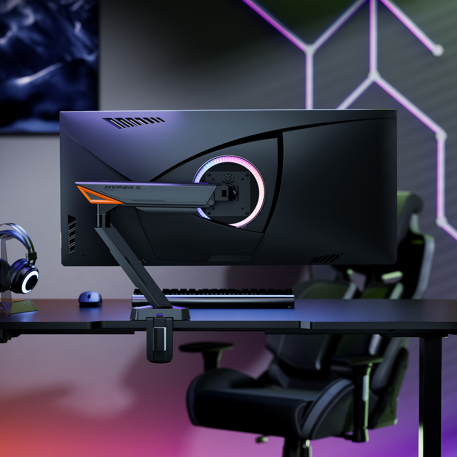 Un monitor y un brazo de monitor en un escritorio. El monitor es negro, y el brazo es plateado con detalles en naranja.