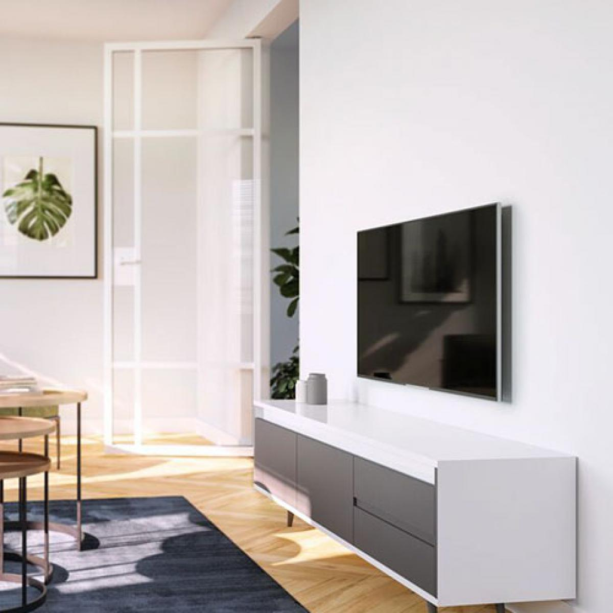 Soggiorno con TV a parete, mobile bianco e grigio e pavimento in legno.