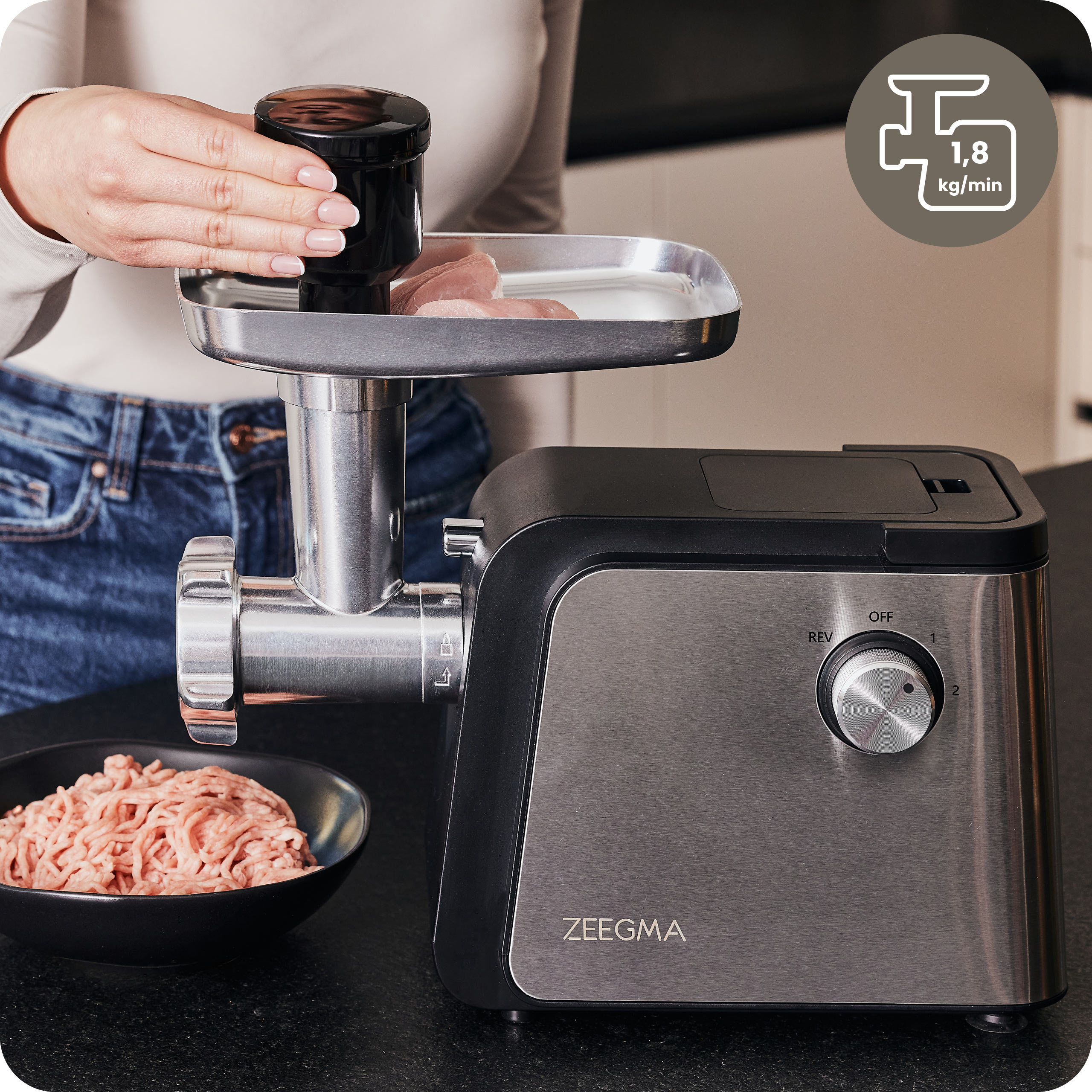 Kobieta używa maszynki do mięsa z mielonym mięsem.