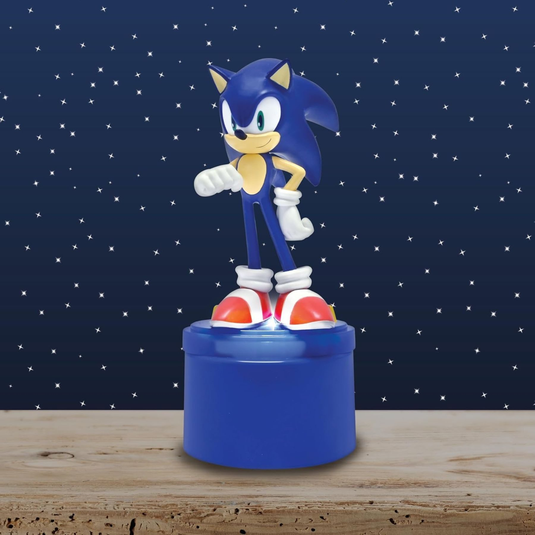 Sonic-Figur auf blauem Sockel. Sternenhintergrund. Holztisch.