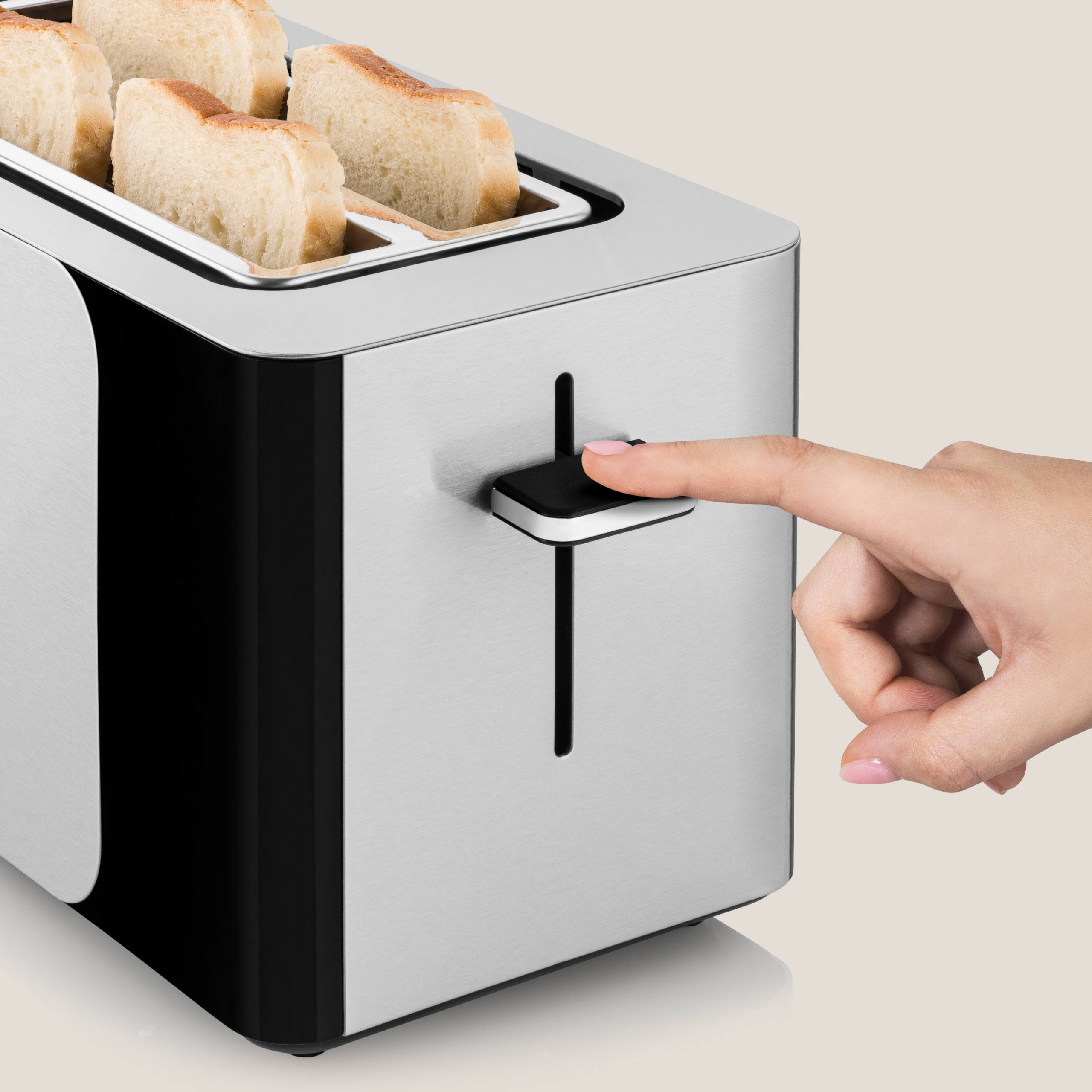 Ręka naciskająca dźwignię tostera z chlebem w środku.