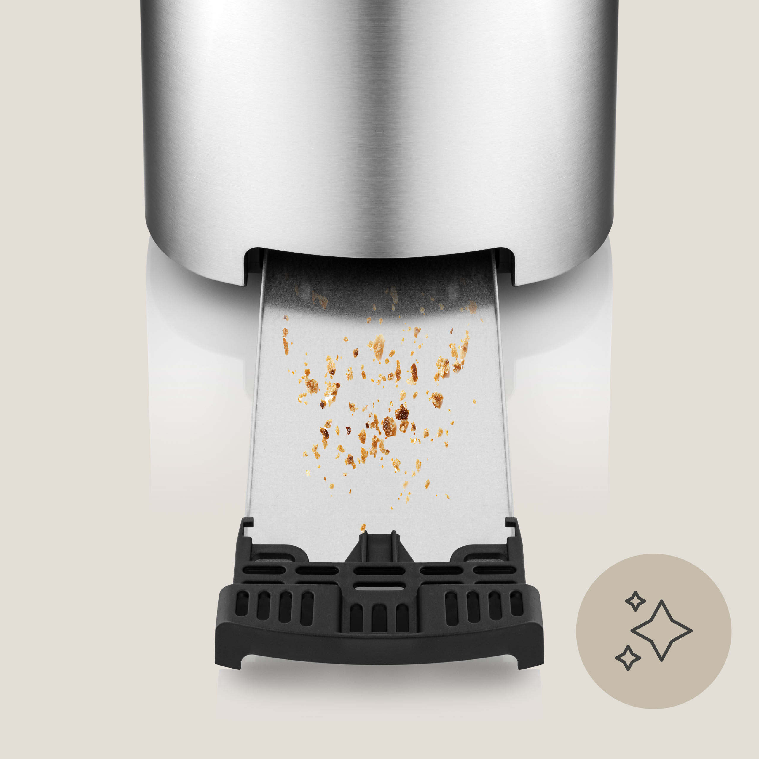 Srebrno-czarny toster z tacą na chleb. Widoczne okruchy tostów.