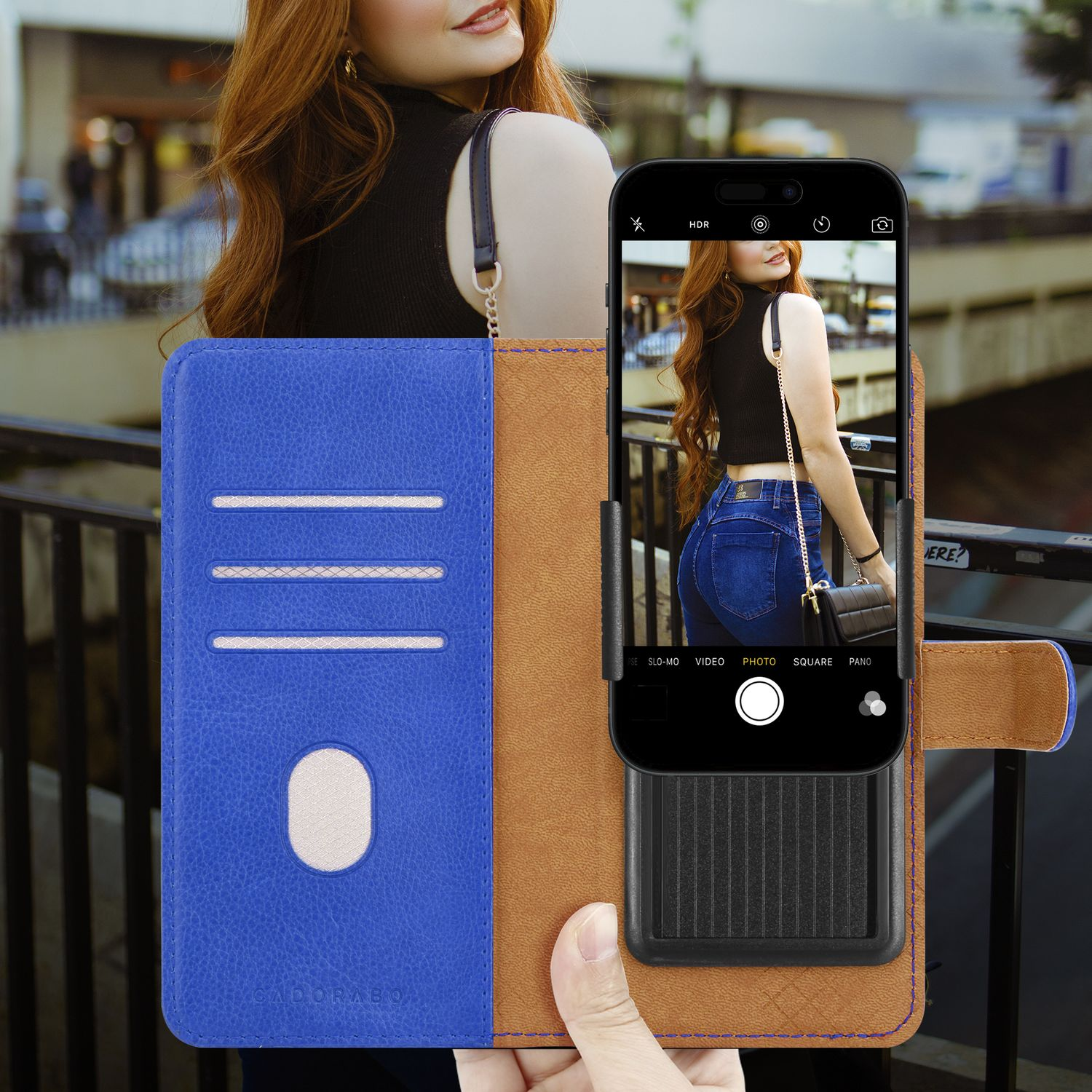 Telefon in einer blau-braunen Brieftasche, zeigt ein Selfie. Frau mit langen roten Haaren.
