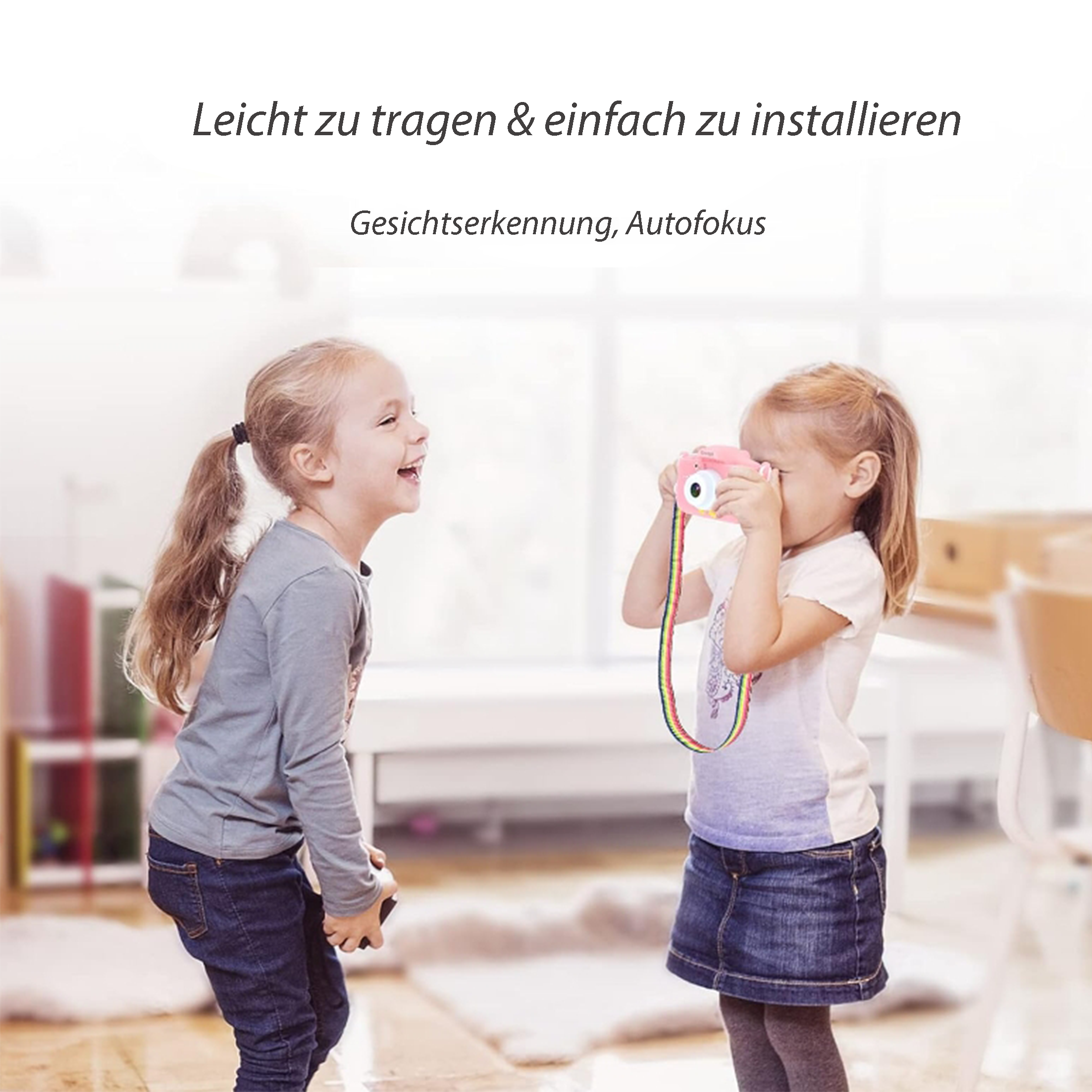 Zwei junge Mädchen, eines lacht, das andere hält eine rosa Kamera.