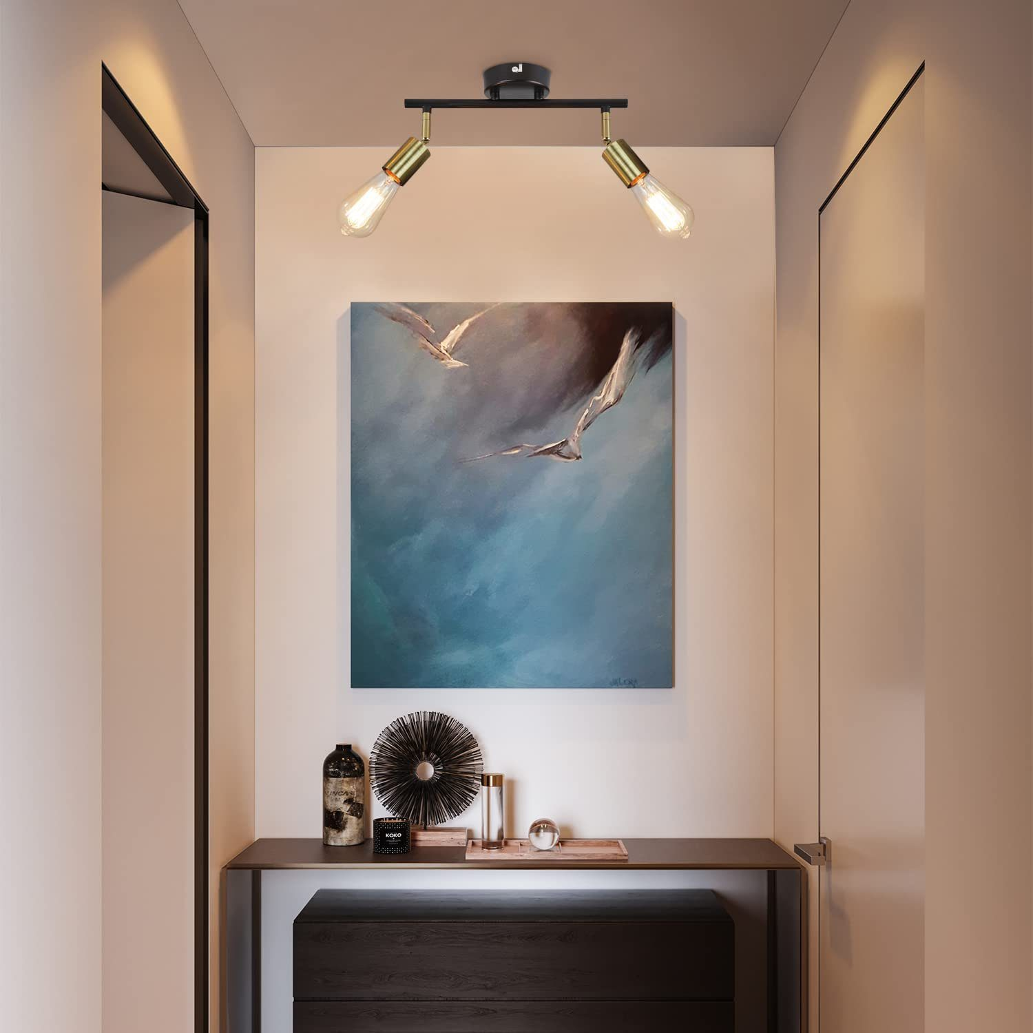 Scena korytarza z obrazem, dwoma oprawami oświetleniowymi i konsolą z elementami dekoracyjnymi na niej.