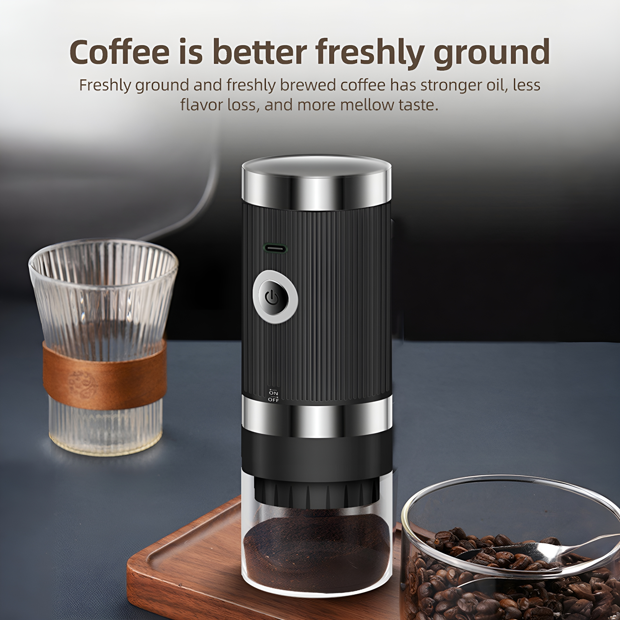 Schwarze und silberne elektrische Kaffeemühle mit Kaffeebohnen und einem Glas Kaffeepulver.