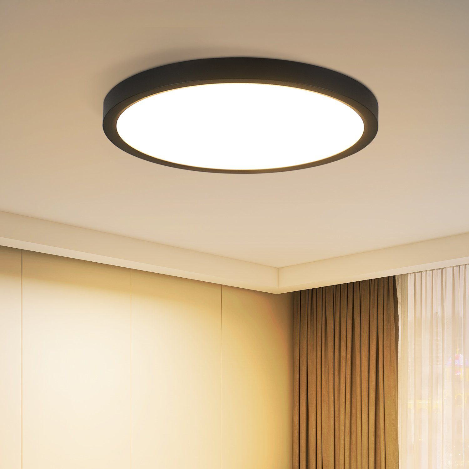 Un apparecchio di illuminazione a soffitto rotondo e bianco contro un soffitto bianco e una parete beige-marrone.