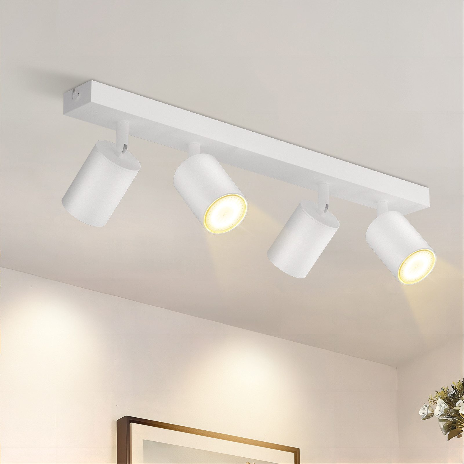 Apparecchio di illuminazione a soffitto bianco con quattro faretti orientabili.