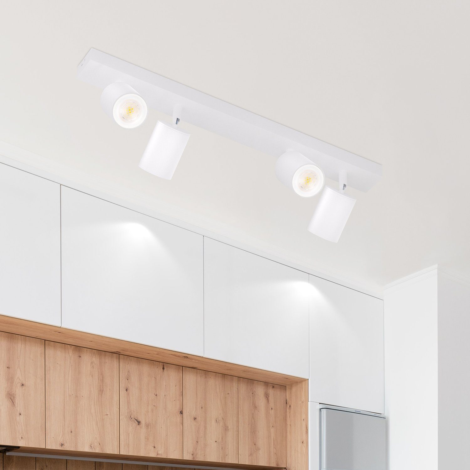 Faretti da soffitto bianchi con tre luci, montati su una barra bianca.