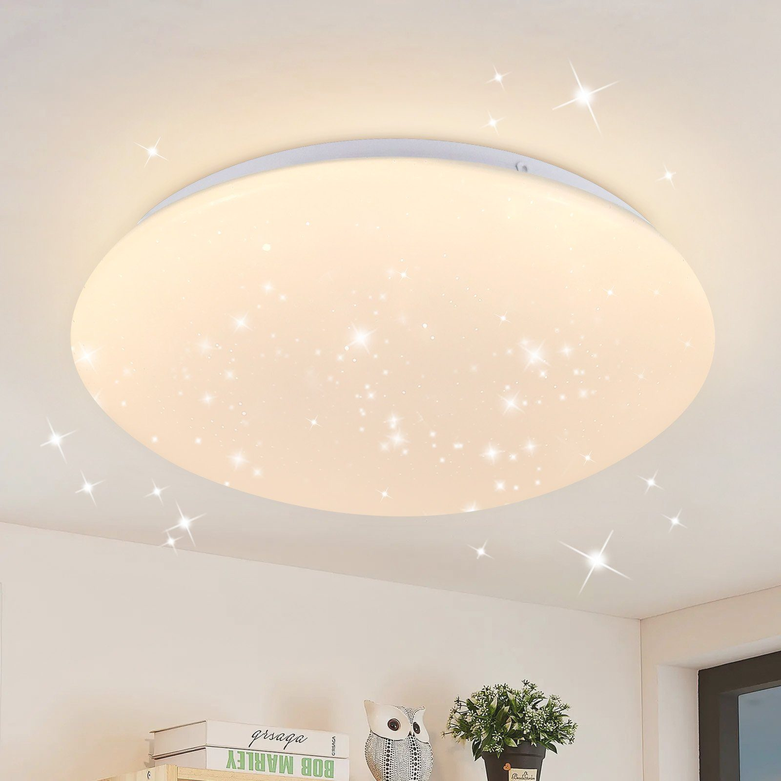 Lampada da soffitto rotonda con stelle. È luminosa ed è installata a soffitto.