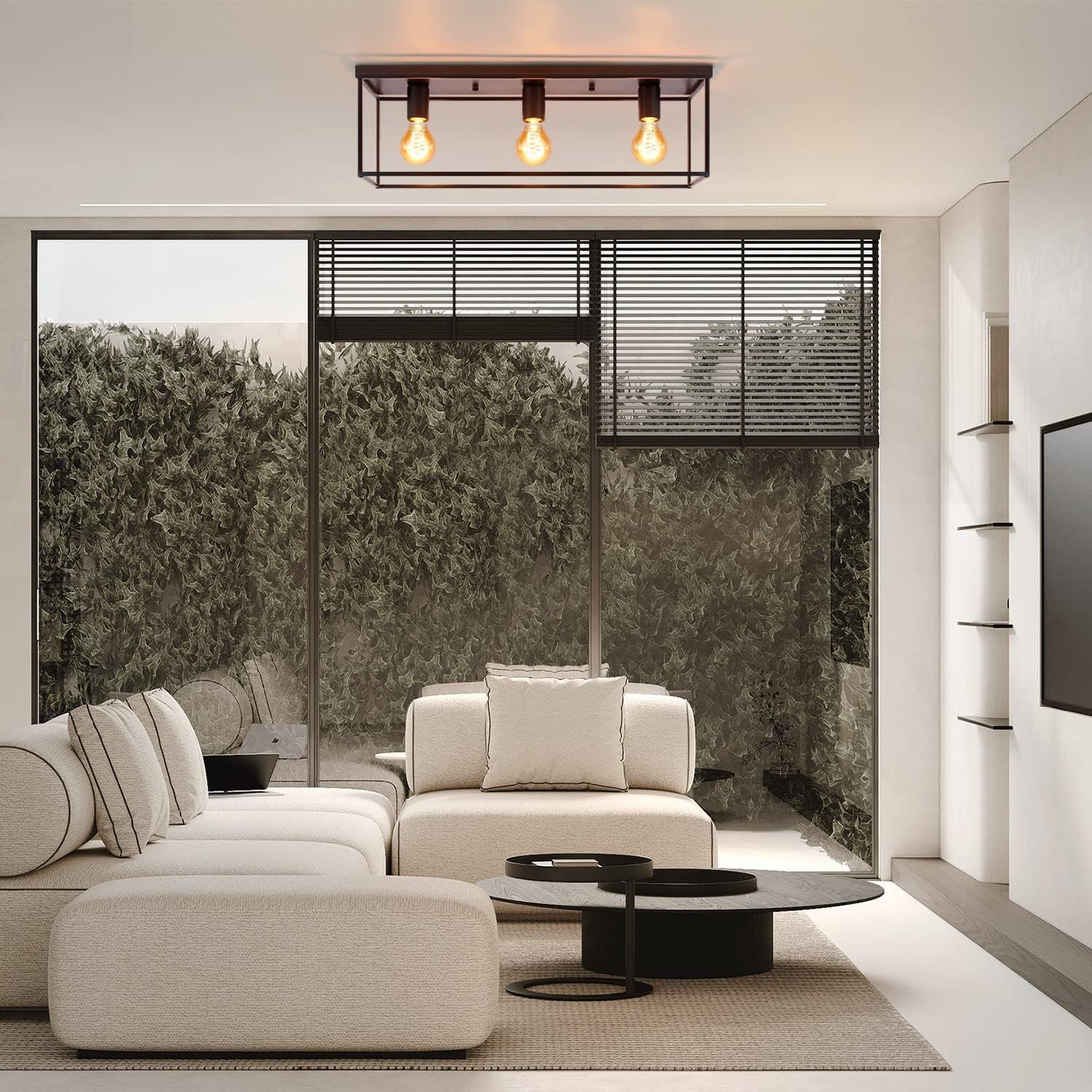 Modernes Wohnzimmer mit beigem Sofa, schwarzen Deckenleuchten und Glastür mit Außenansicht.