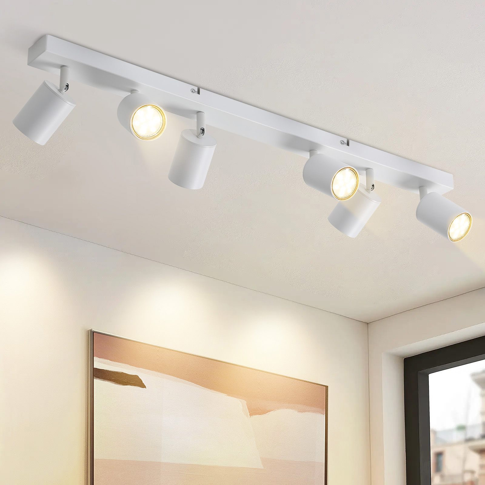 Illuminazione a binario bianca con faretti orientabili a soffitto. Le luci sono accese.