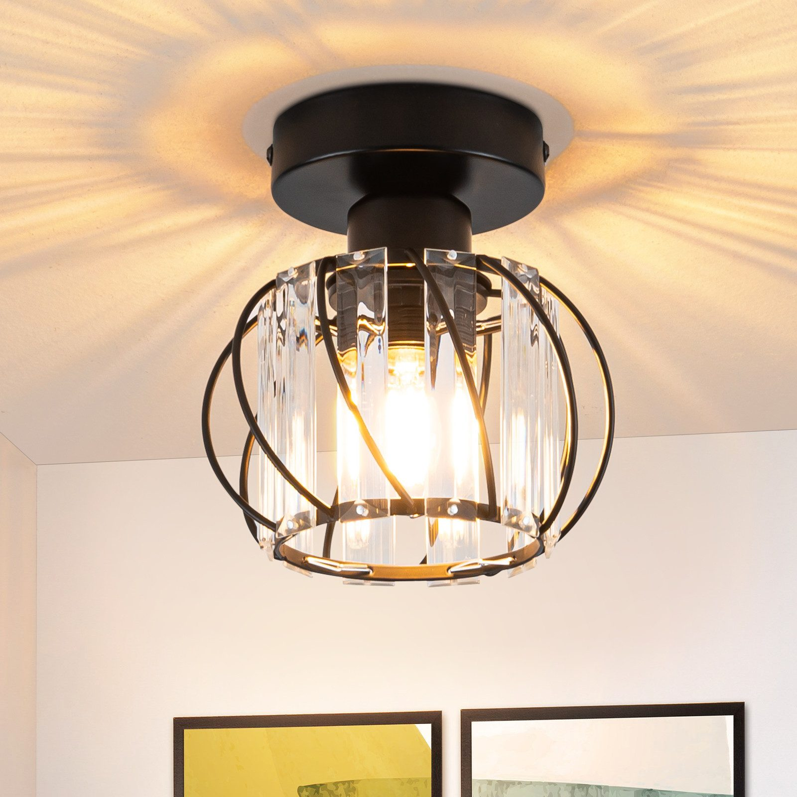 Un apparecchio a soffitto con base nera e involucro di vetro. La luce è accesa.