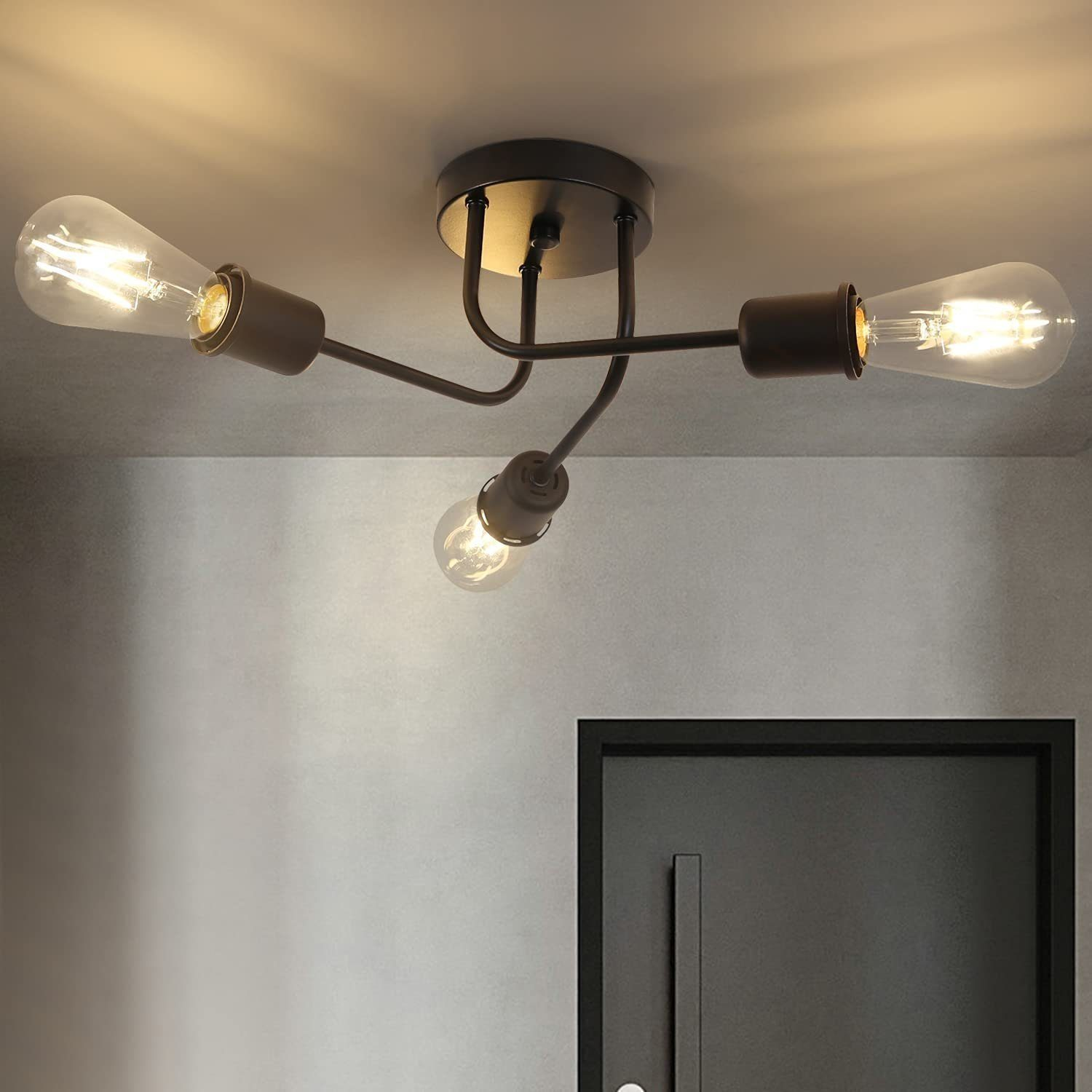 Lampada da soffitto con tre lampadine. Un apparecchio marrone scuro è montato su un soffitto bianco.